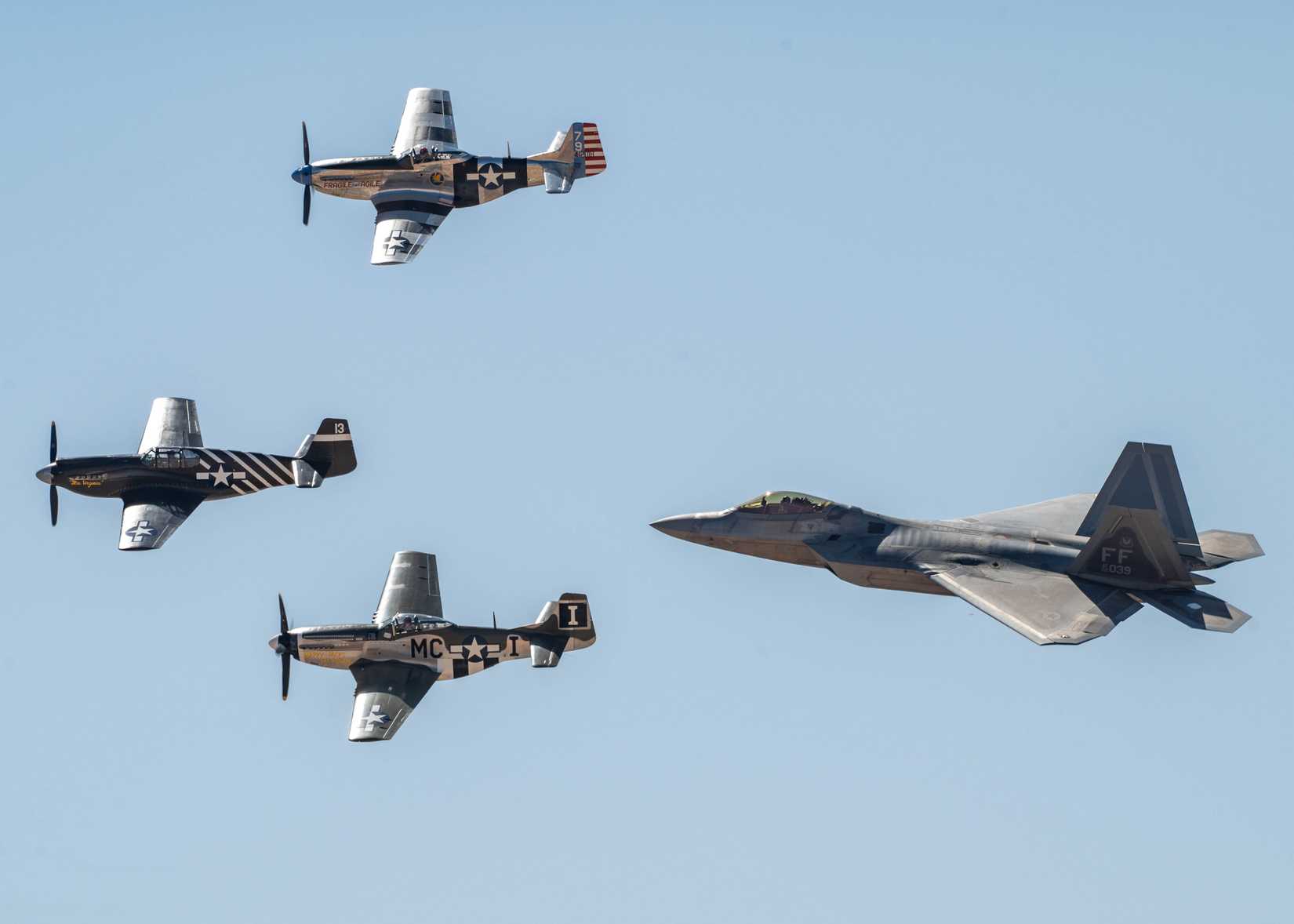 A U.S. Air Force F-22 Raptor aircraft flies in formation with three P-51 Mustang aircraft during the Heritage Flight Training Course at Davis-Monthan Air Force Base, Arizona.