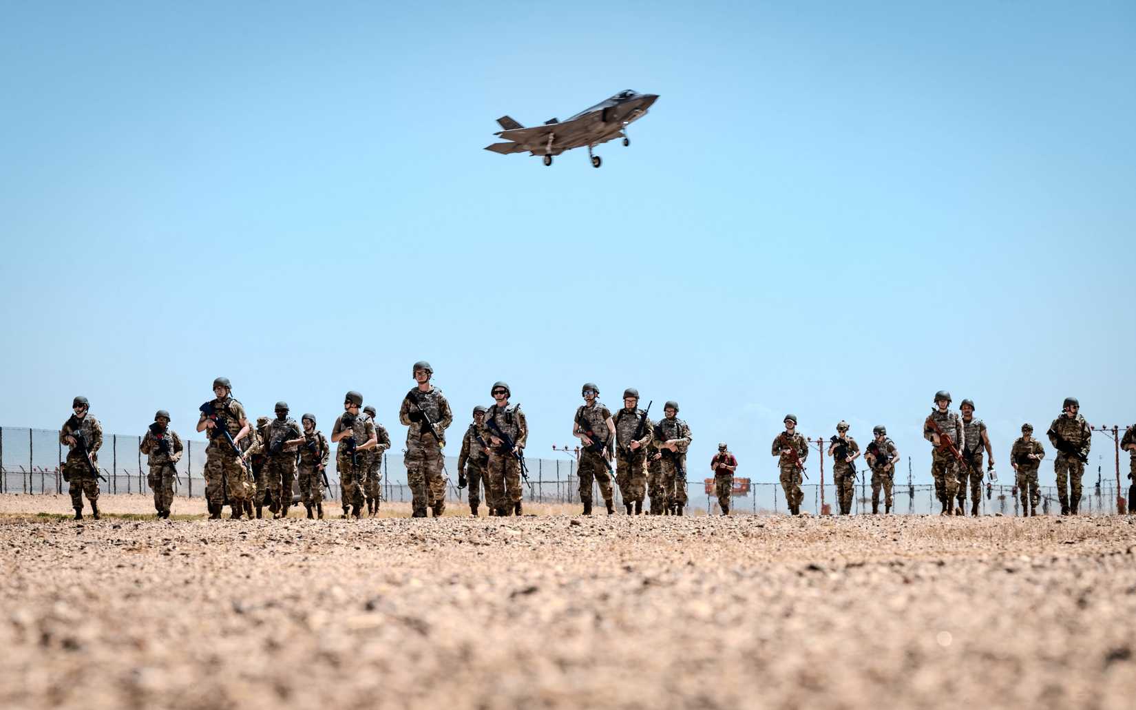 Airmen march to a forward operating point near the flightline as an F-35A Lightning II prepares to land at Luke Air Force Base, Arizona.