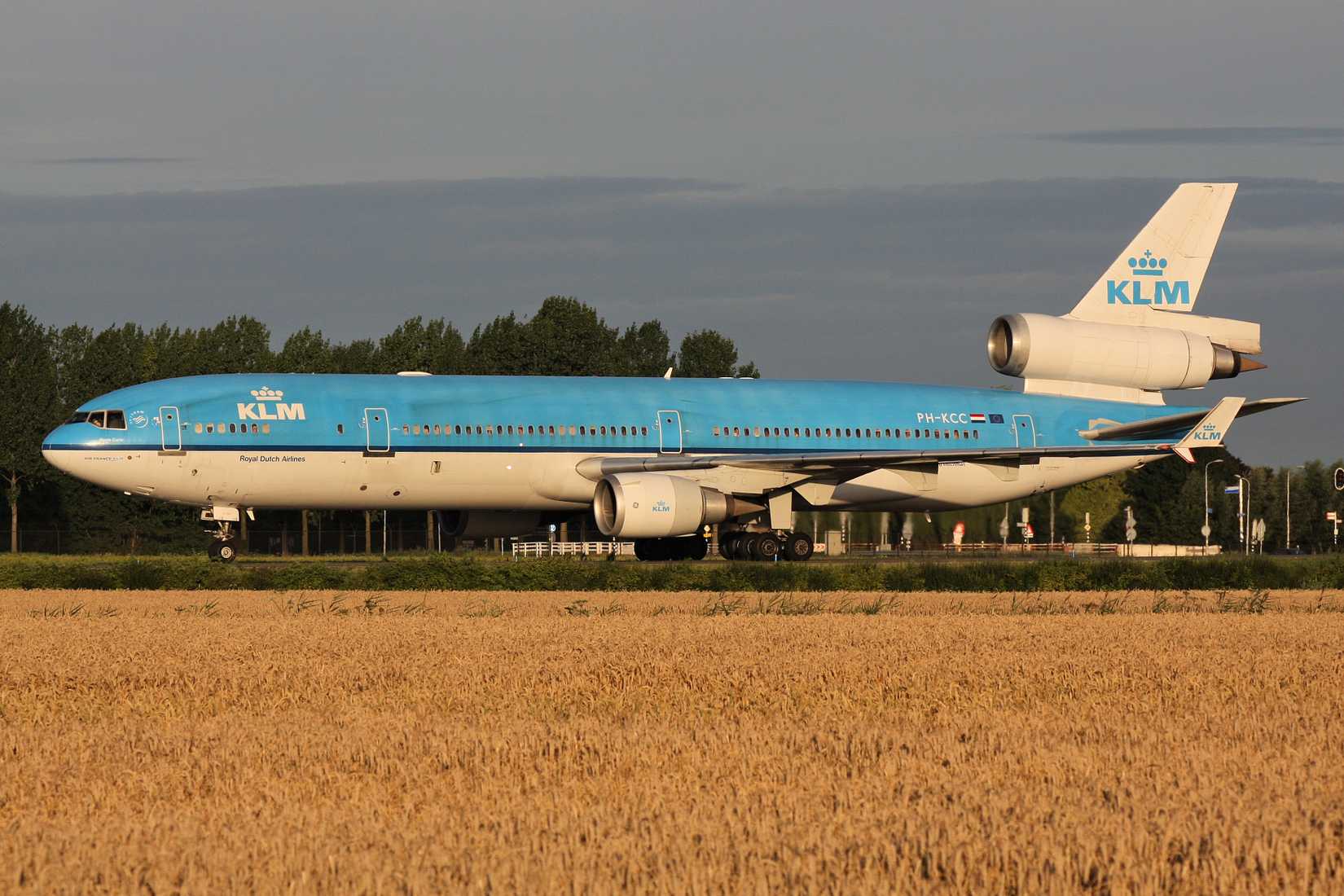 Dutch KLM McDonnell Douglas MD-11 with registration PH-KCC rolling on taxiway V of Amsterdam Airport