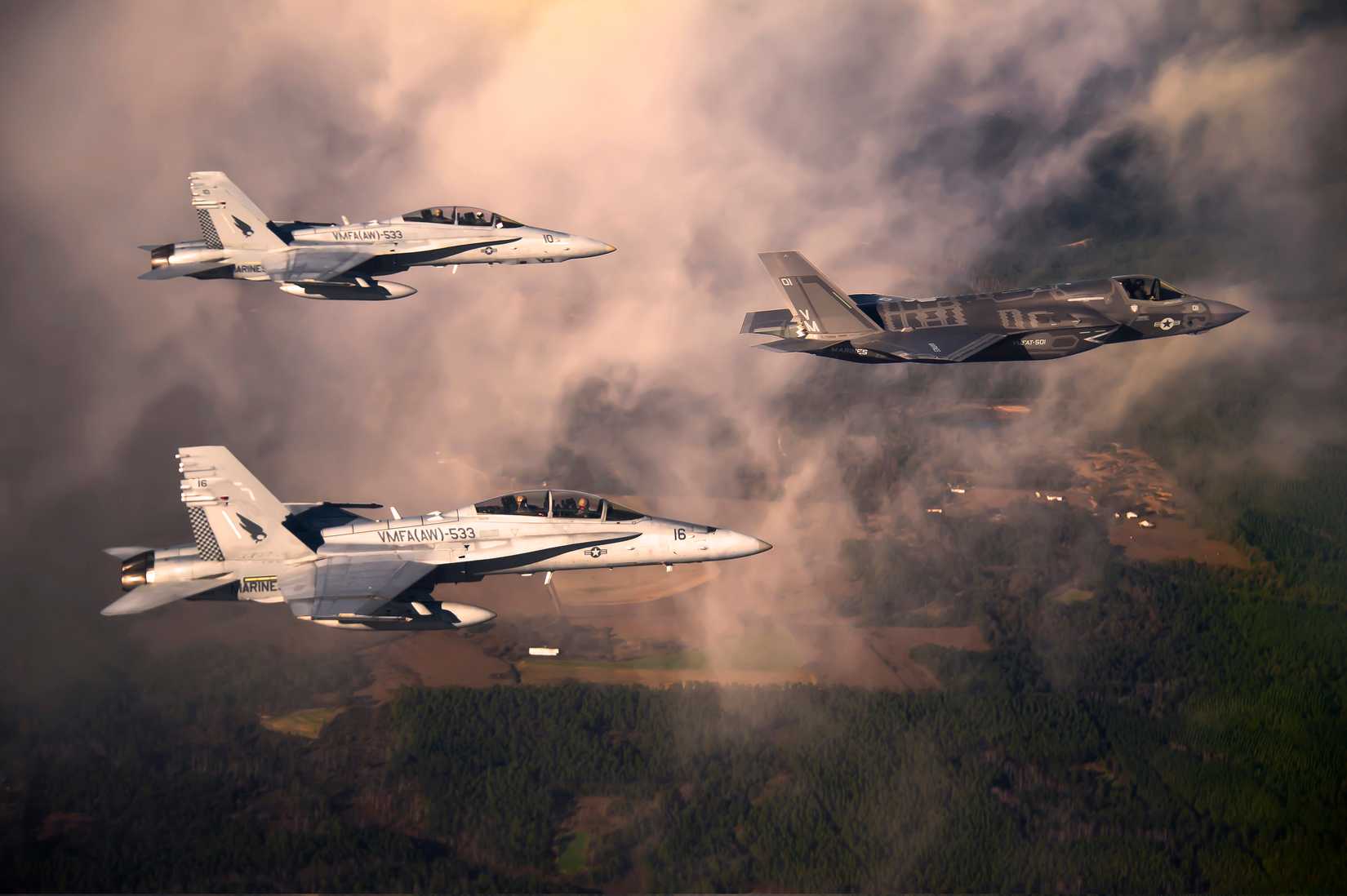 Marine Corps F-35 Lightening II aircraft is escorted by two Marine FA-18 Hornets as it flies toward Eglin Air Force Base.