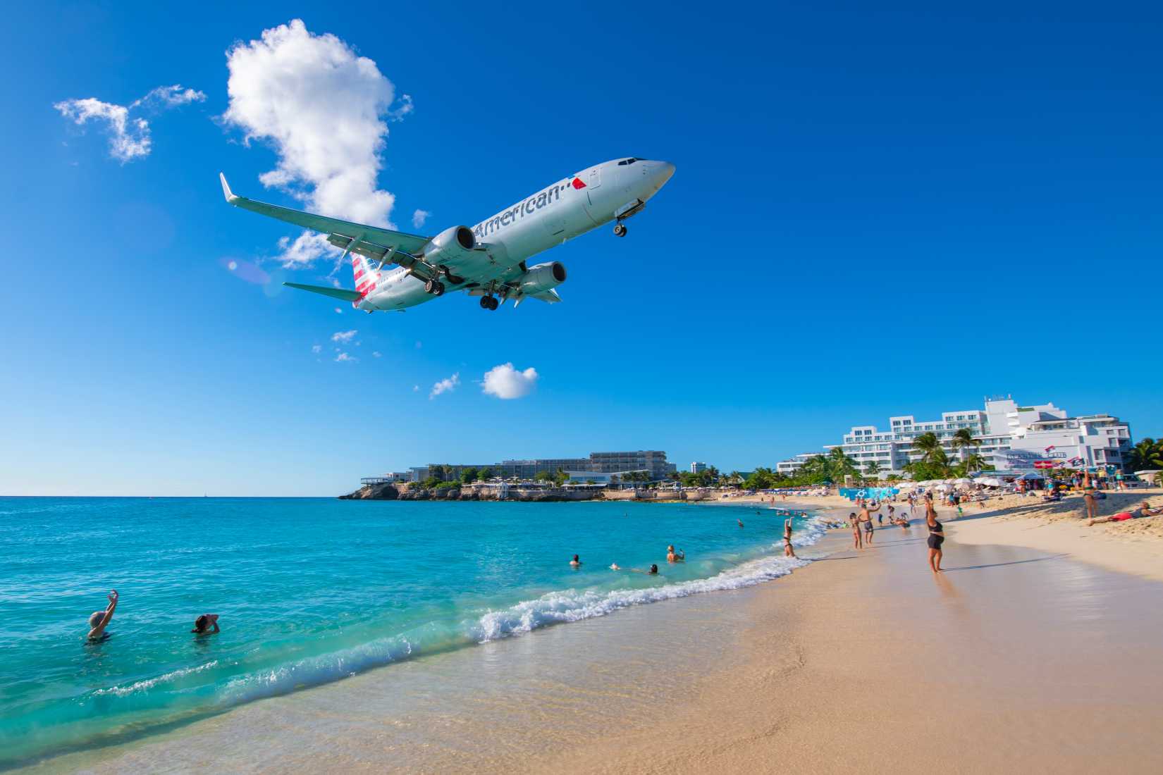 merican Airlines Boeing 737-800 N861NN flying over Maho Beach before landing on Princess Juliana International Airport.
