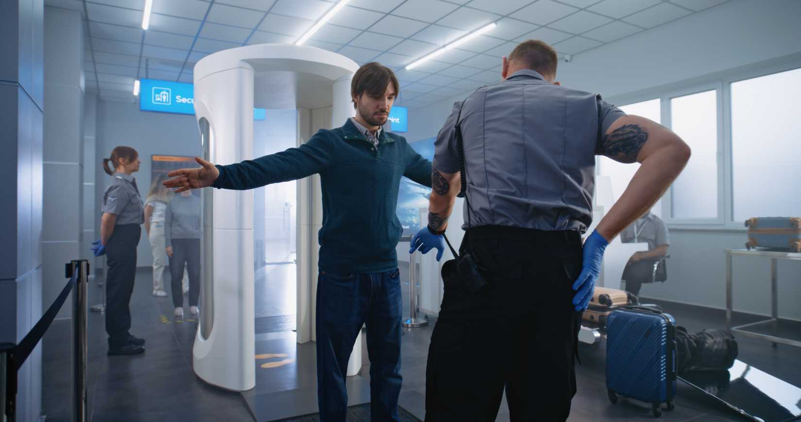 Airport Terminal Security Check: Adult Man, Tourist Passes Through Metal Detector Scanner Gates. Security Officer Checks Passenger for Boarding Plane Flight. Diverse Travelers Going on Holiday Trips.