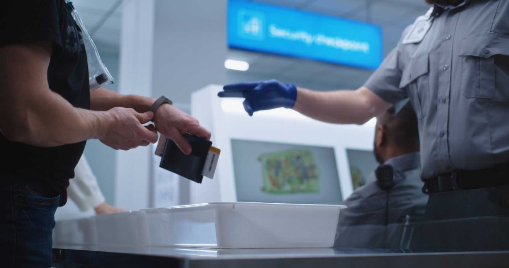 Airport Security Checkpoint during Boarding Flight. Diverse Passengers Put Personal Belongings in Plastic Trays for Scanning: Tablet Computer, Phone, Documents. Security Officers Control Procedures