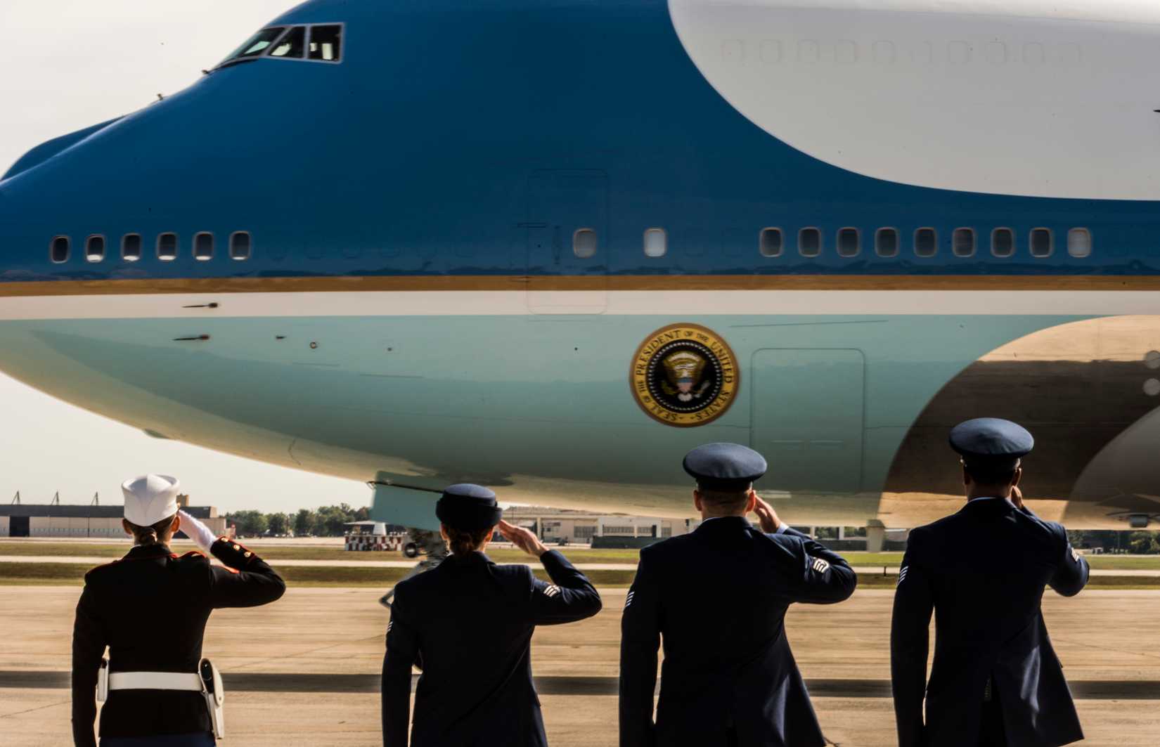 The VC-25A, Air Force One, is saluted by service members.