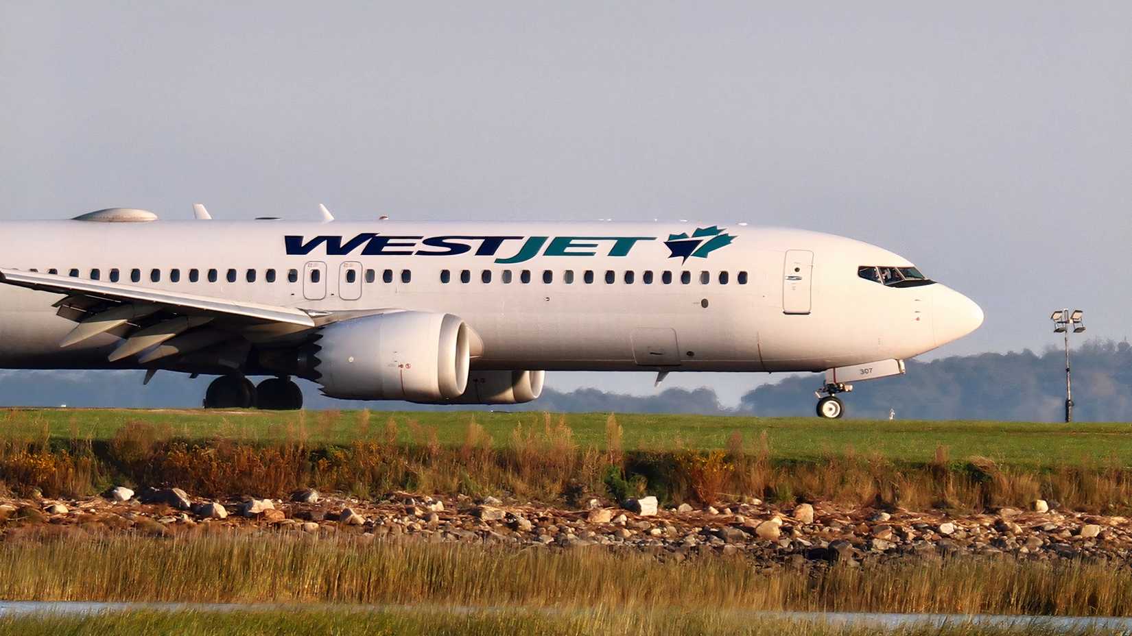 WestJet Boeing 737 MAX 8 on the ground ahead of another flight