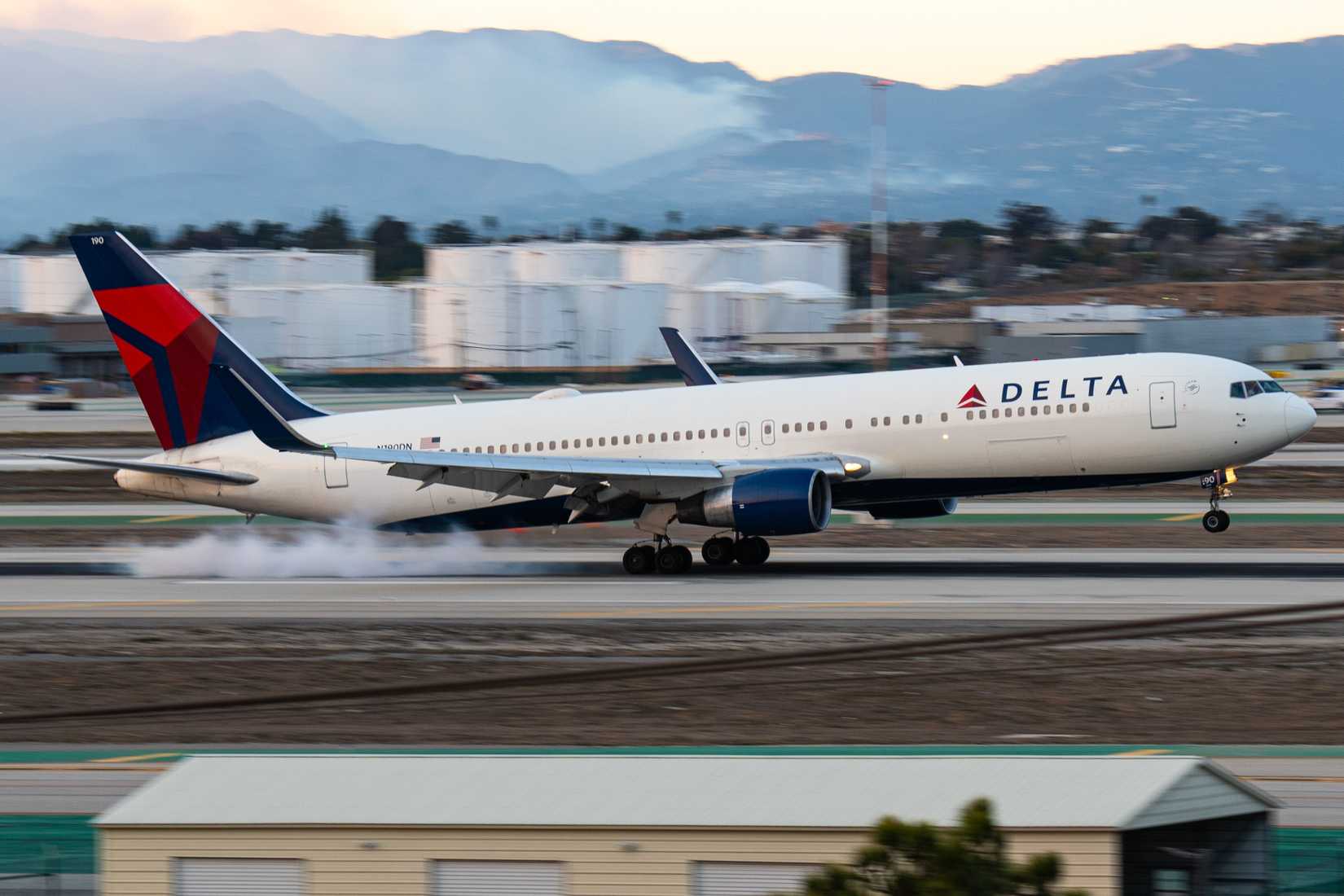 A Delta Airlines Boeing 767 landing in LAX with the Palisades fire in the background.