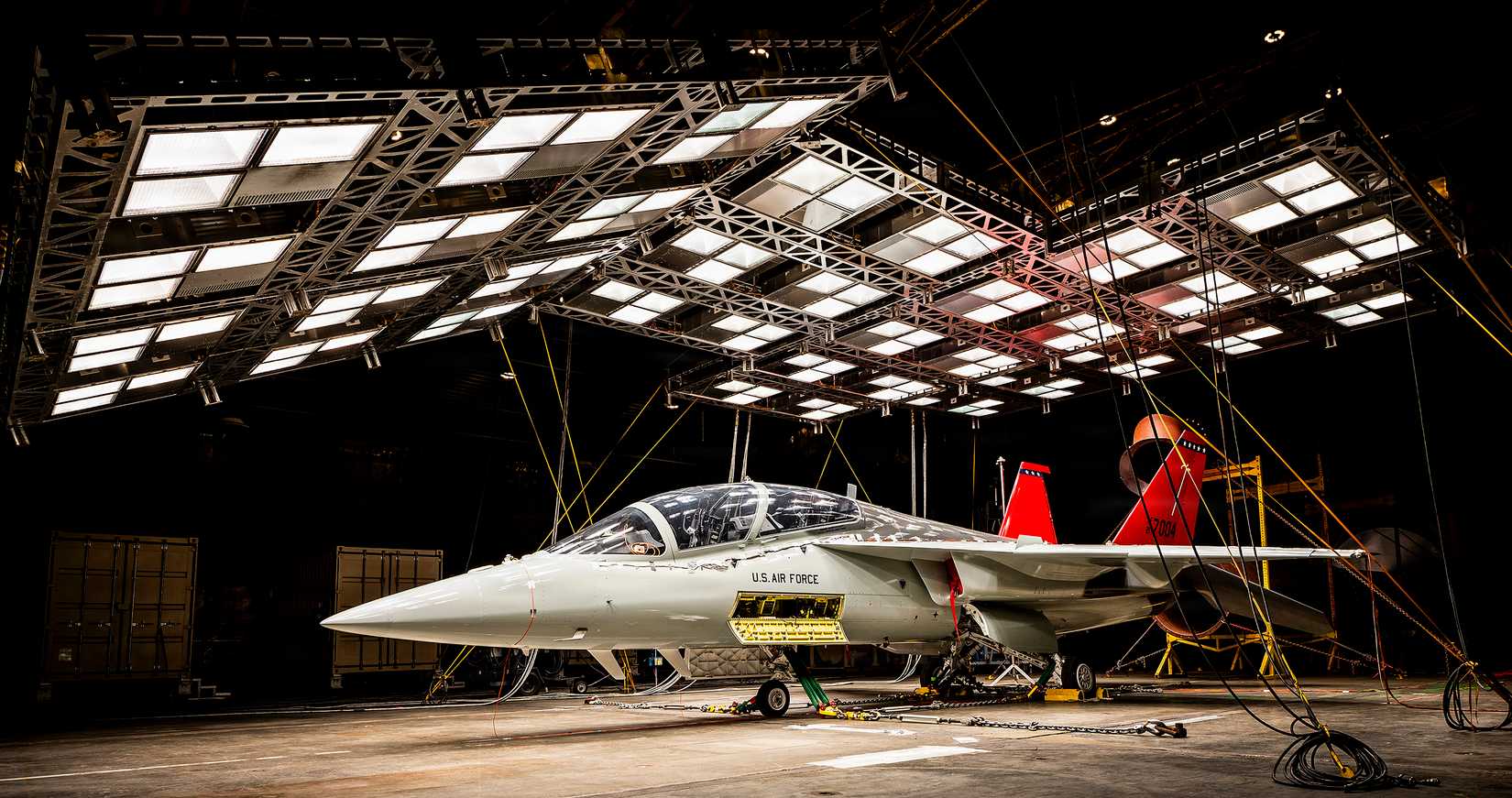 A T-7A Red Hawk sits under bright lights used to create heat in the McKinley Climatic Lab.
