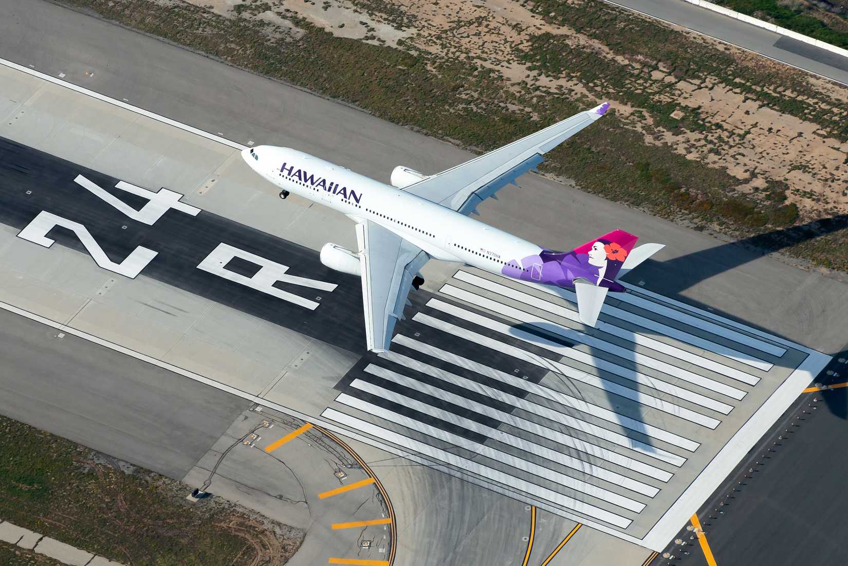 Aerial view of Hawaiian Airlines Airbus A330 over runway 24R marks (piano keys) inbound from Honolulu.