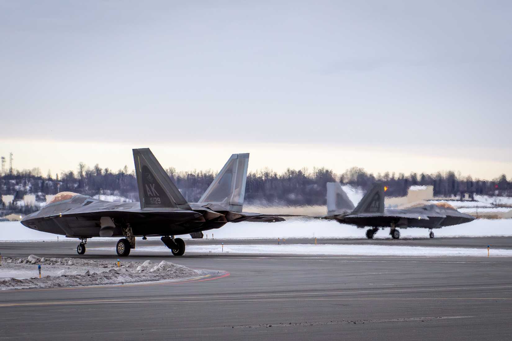 Air Force F-22 Raptors assigned to the 3rd Wing taxi to the runway on Joint Base Elmendorf Richardson, Alaska.