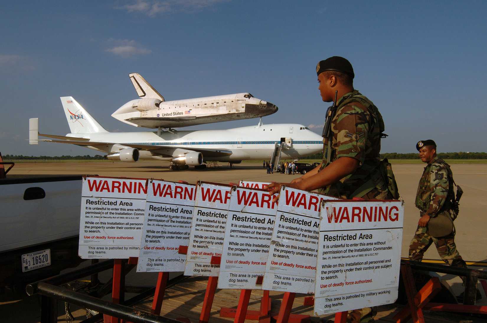 Air Force Security Forces personnel set up a security perimeter around the space shuttle Discovery and NASA's 747 Shuttle Carrier.