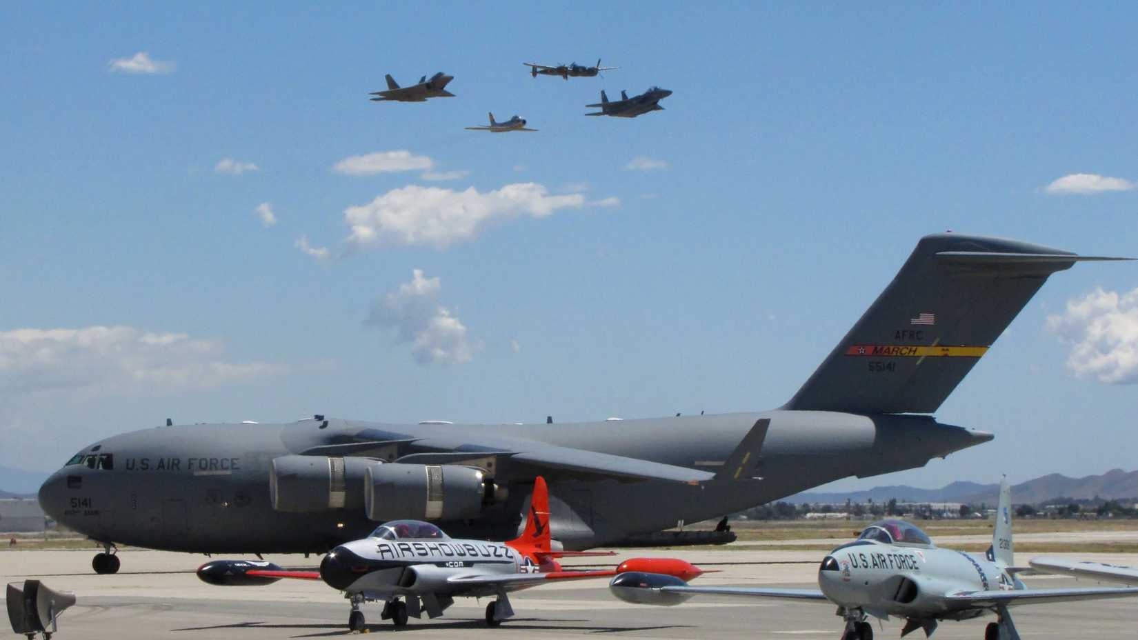  A C-17 taxi's by as the Air Force Heritage Flight with an F-22, F-15, P-38 and F-86 pass overhead at March Field Airfest 2010.