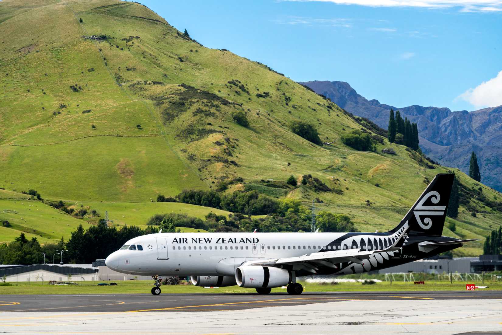 Airplane of Air New Zealand takes off from runway in Queenstown airport.
