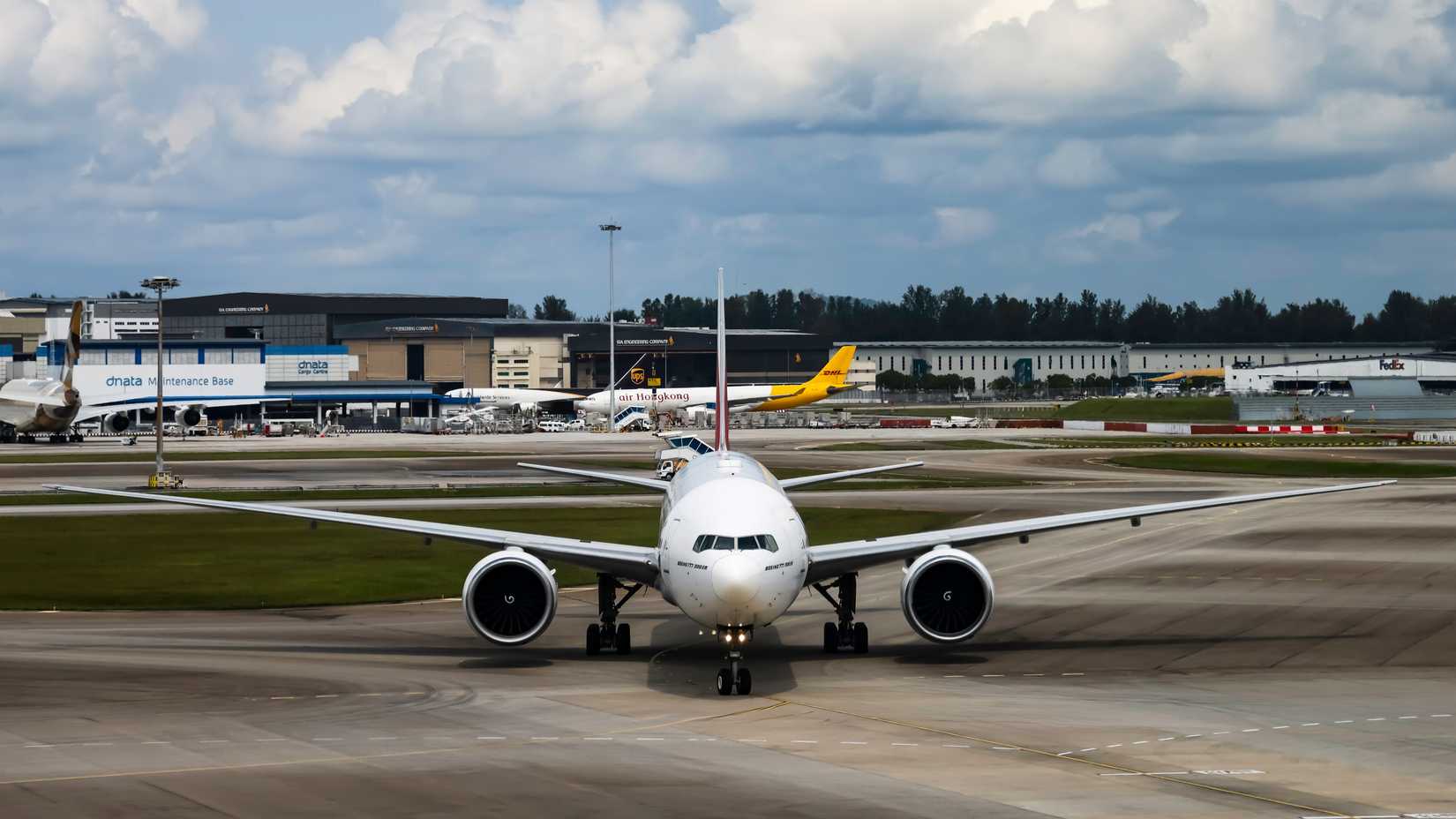 Emirates Boeing 777-300ER taxis to aircraft bay to park, Terminal 1, Changi Airport.