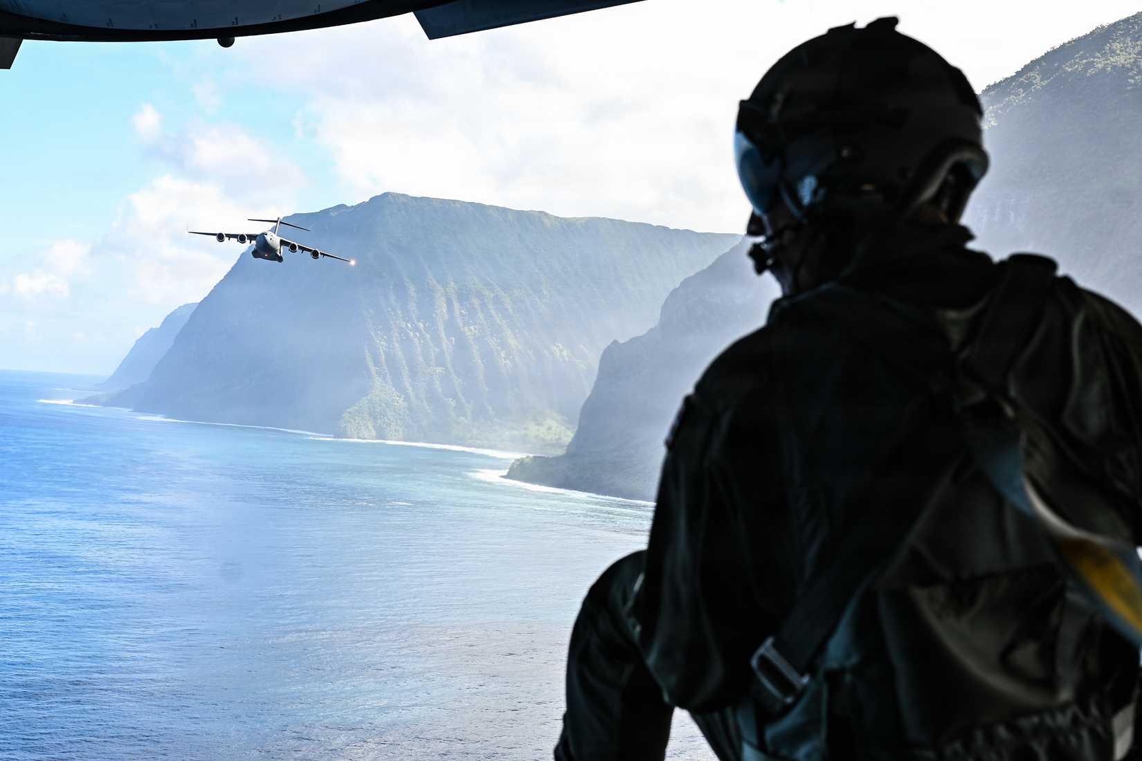 Master Sgt. Chad Thompson, 204th Airlift Squadron loadmaster, Hawaii Air National Guard, observes a C-17 Globemaster III during a low-level route alongside the cliffs of Molokai, Hawaii,