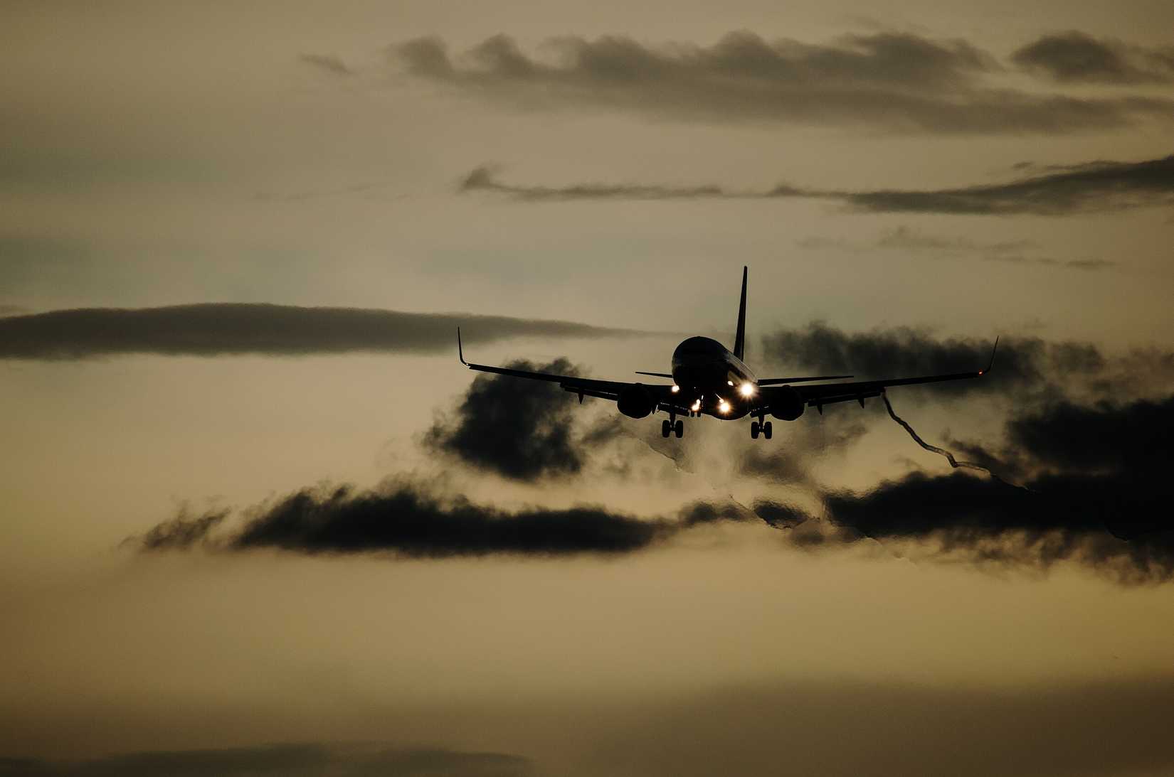An aircraft emerges from turbulent skies for landing