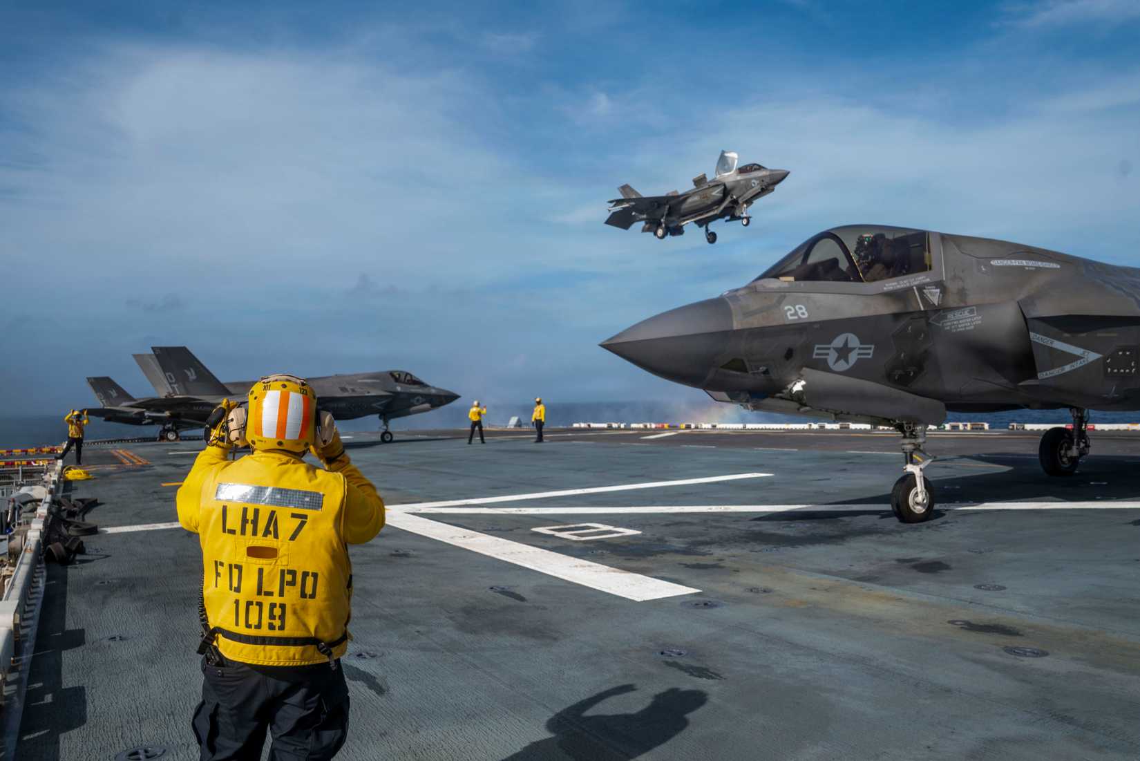 Sailors direct the landing of multiple F-35B Lighting II, attached to Marine Fighter Attack Squadron 242