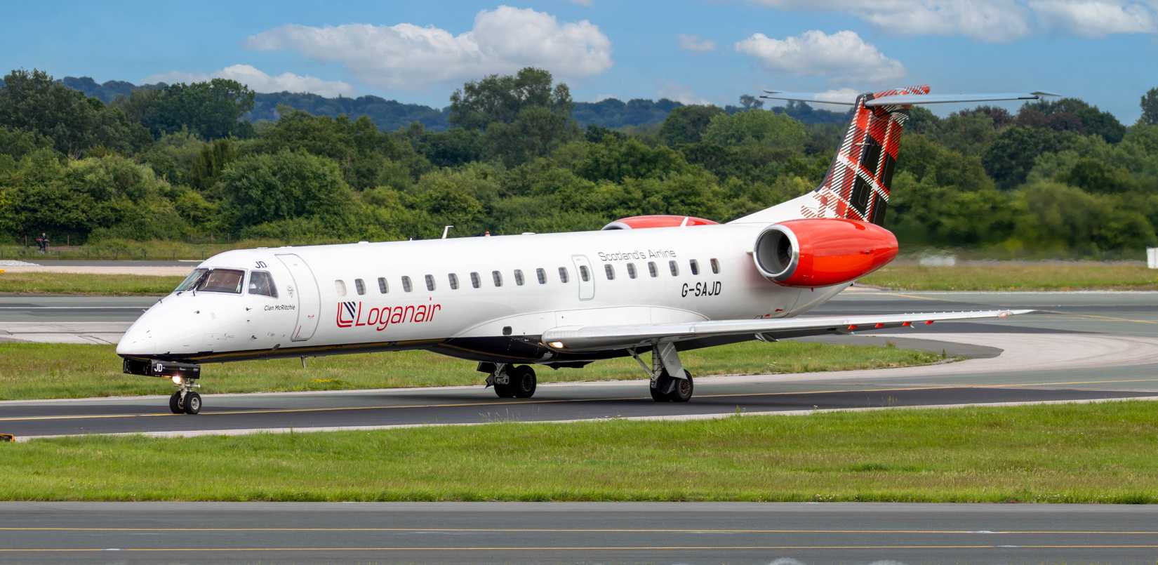 Scottish Logan Air taxiing on the runway of Manchester Airport.