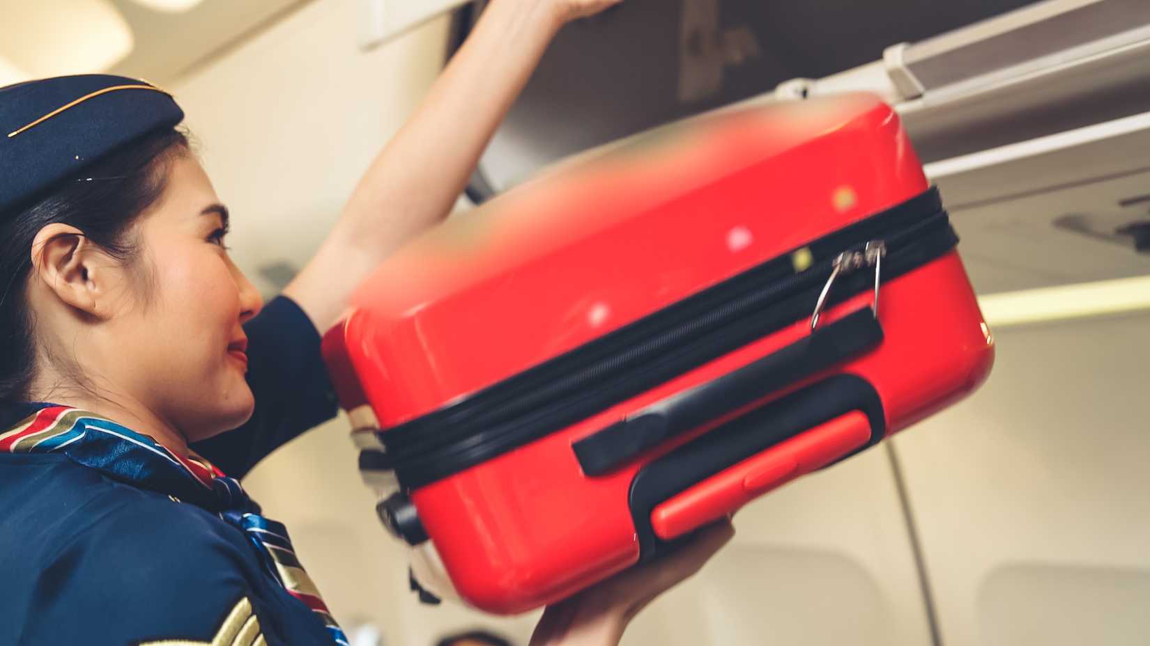 Flight attendant handling baggage.