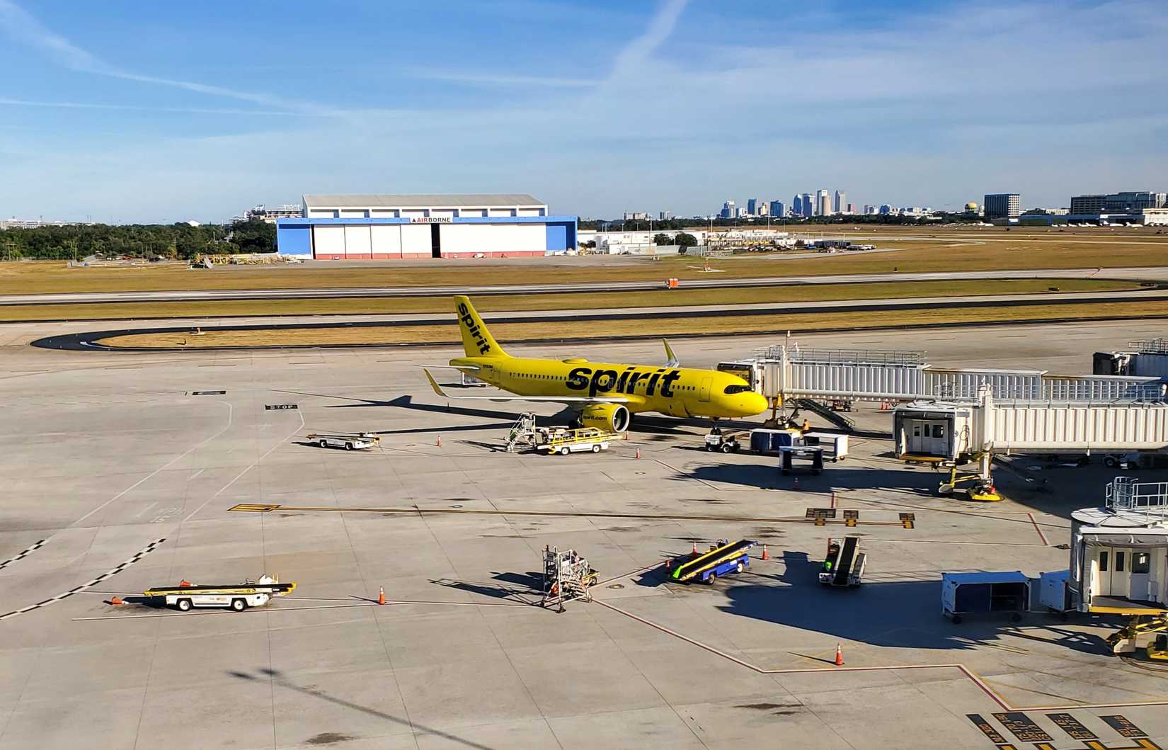 Spirit Airlines aircraft at Tampa International Airport gate with jet bridge.