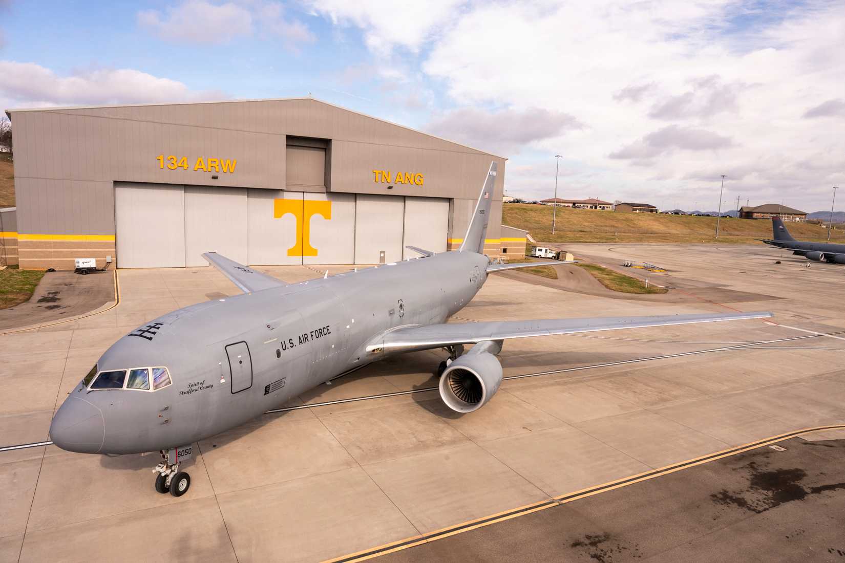 A KC-46A Pegasus sits on the flight line outside a 134th Air Refueling Wing hangar