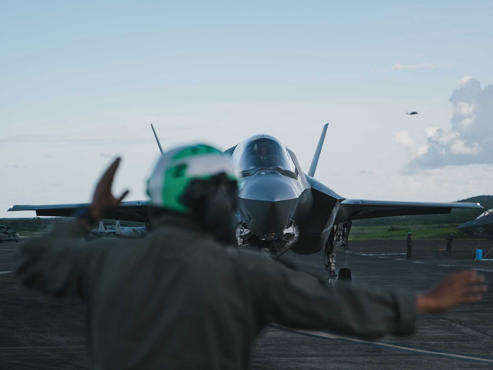 A Marine Fighter Attack Squadron (VFMA) 225 plane captain, signals to a pilot in a F-35B on the flightline 