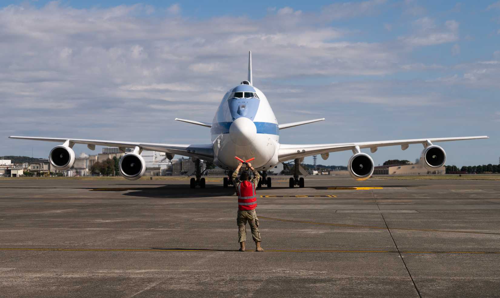 Air Force Airman marshals a U.S. Air Force E-4B Nightwatch transporting U.S. Secretary of Defense