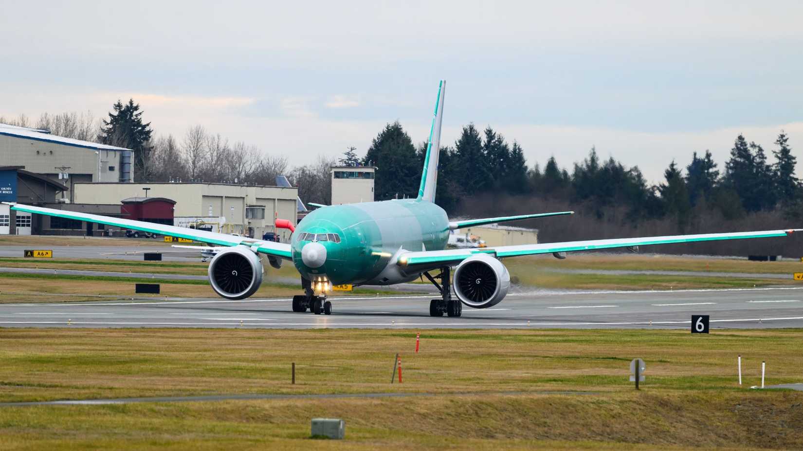 Boeing 777F freighter aircraft in pre delivery green on runway 34L at Paine Field.