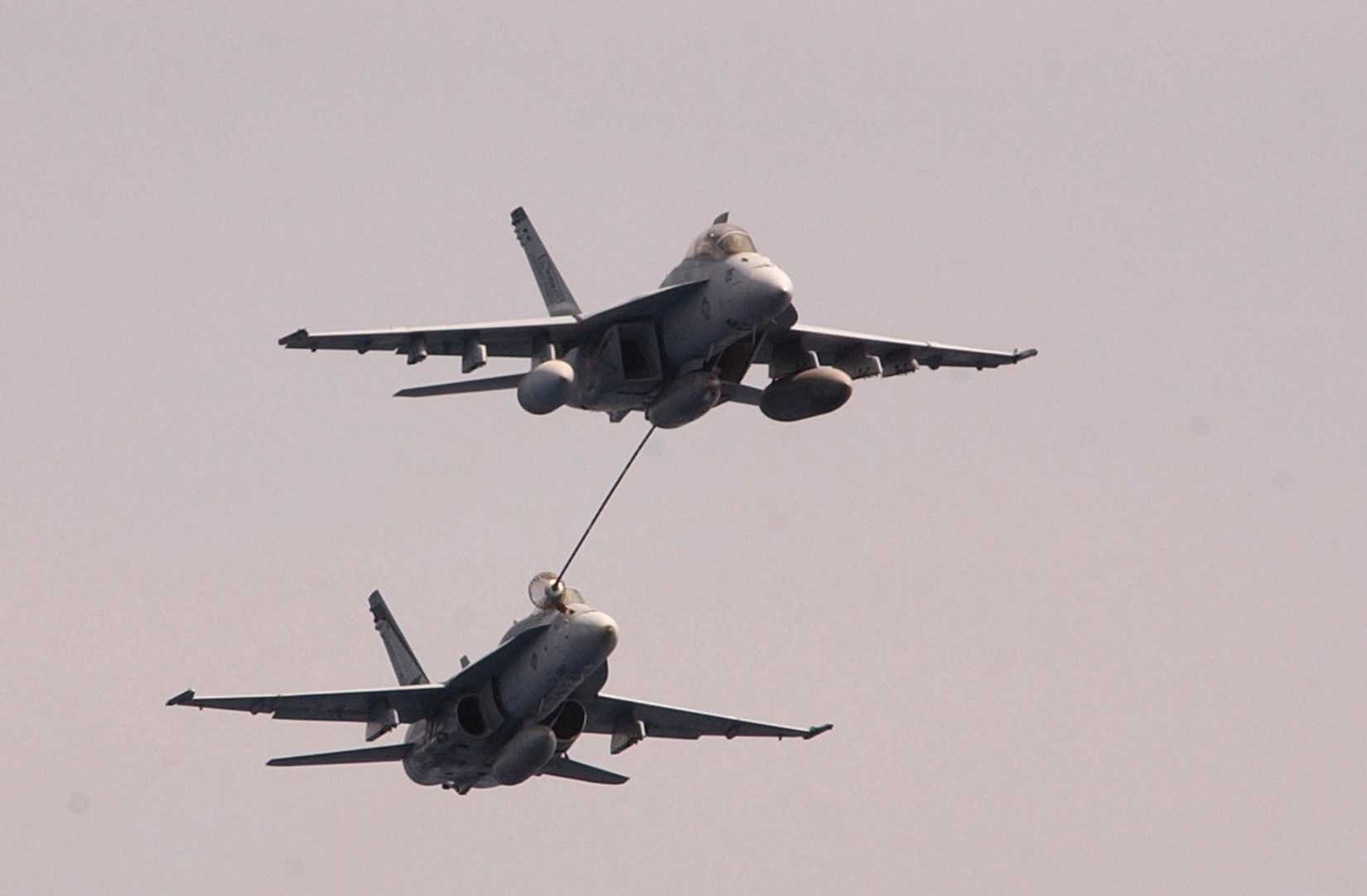 An F/A-18F Super Hornet and an F/A-18C Hornet demonstrate air-to-air refueling for guests and Sailors assigned to the aircraft carrier USS Nimitz (CVN 68) during a Family and Friends Day Cruise.