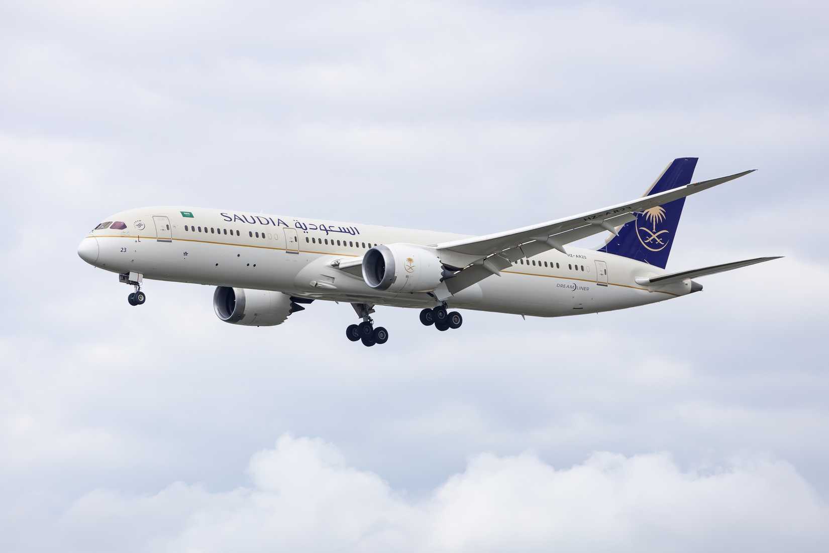Saudi Arabian Airline, Saudia, Boeing 787 Dreamliner, registration HZ-AR23 coming in to land across a bright white sky.