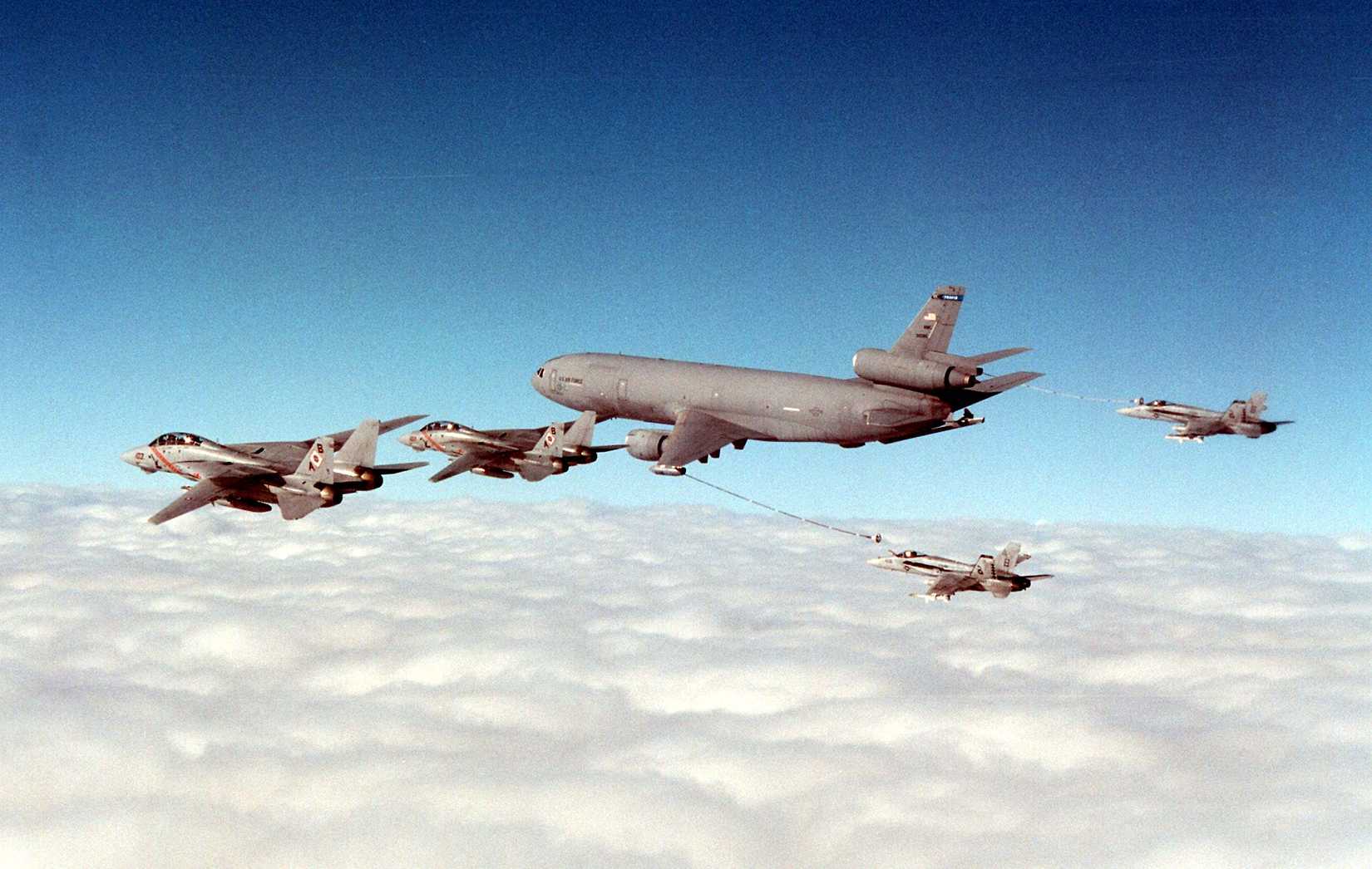 Two Navy F-14B Tomcats (left) fly in formation with a Air Force KC-10 Extender (center) as it refuels two Navy FA-18C Hornets (right) over the Persian Gulf, 1997.