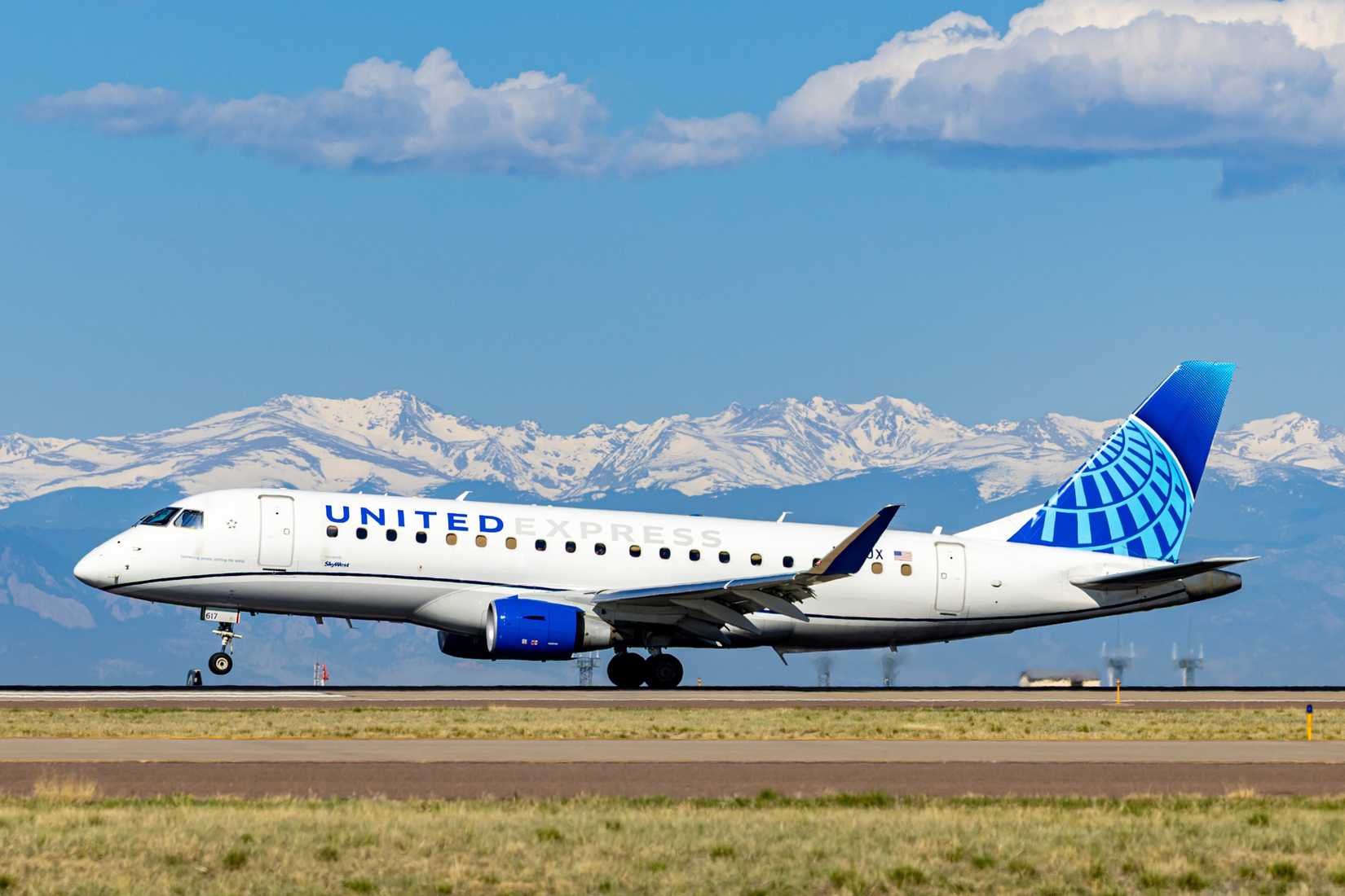 United Airlines Embraer E175 landing with mountains in the background