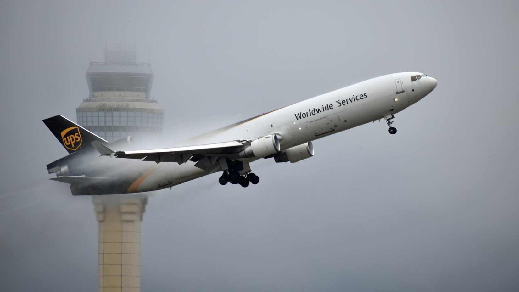 A UPS (United Parcel Service) McDonnell Douglas MD - 11 freighter aircraft departs Hartsfield Jackson International Airport.