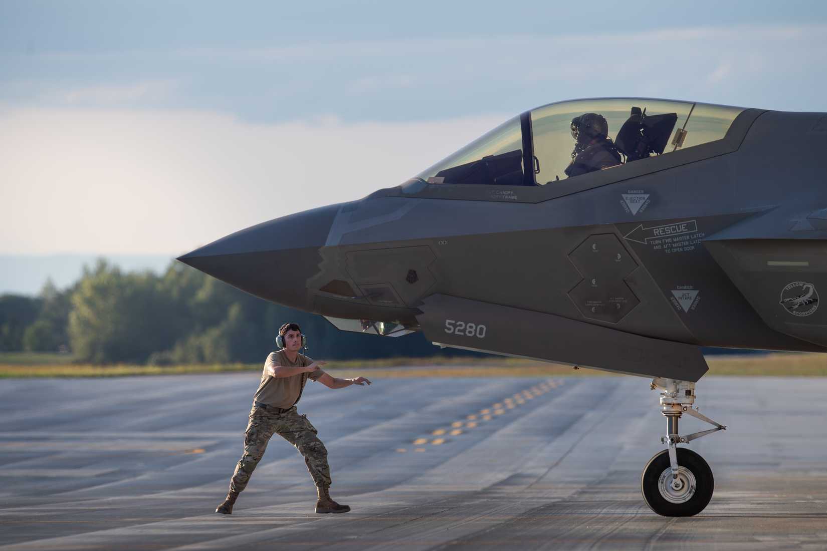 Air Force crew chief, assigned to the 158th Fighter Wing, marshals an F-35A Lightning II.