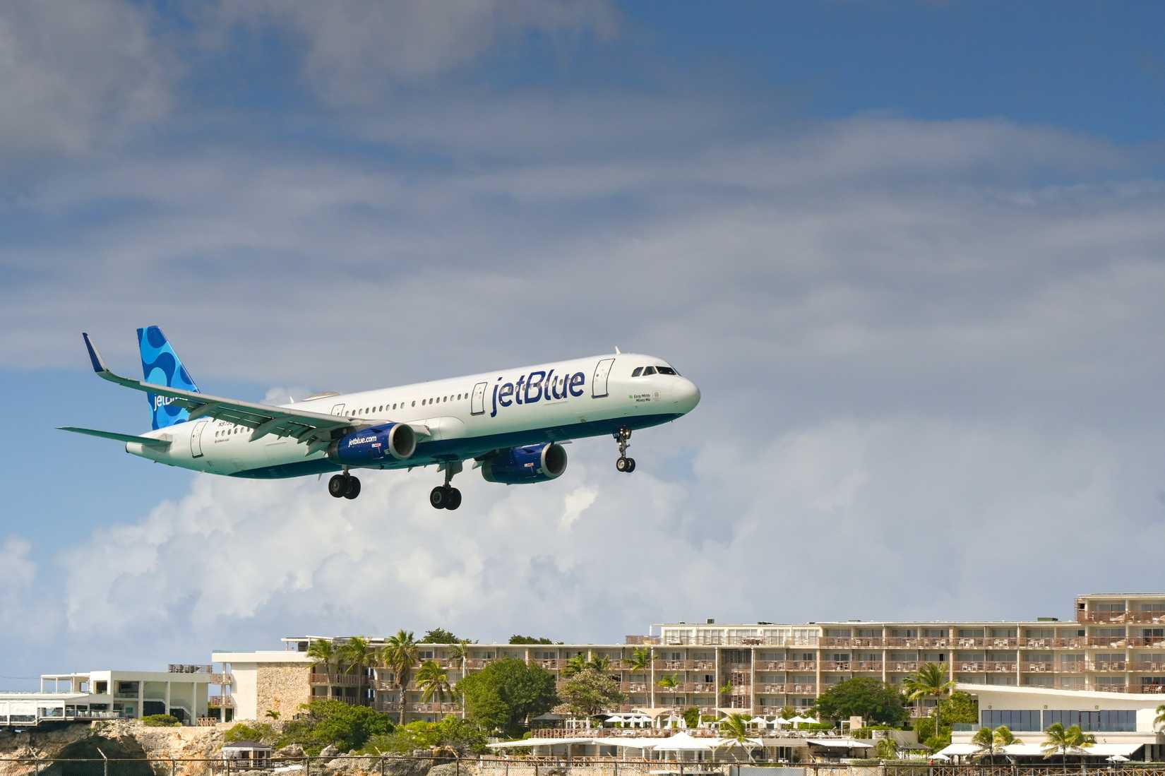 Airbus A321 operated by JetBlue (registration N979JT) flying low over the island's famous Maho Beach to land at the Princess Juliana International Airport.