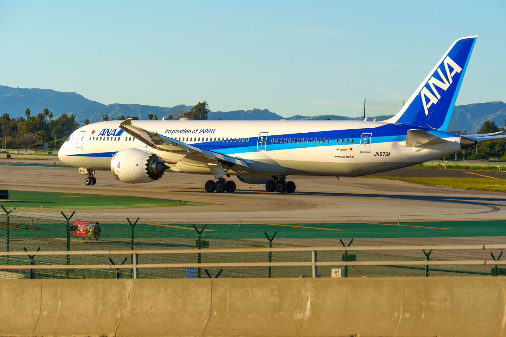 All Nippon Airways Boeing 787 Dreamliner seen taxiing on the sunlit tarmac at Los Angeles Airport.
