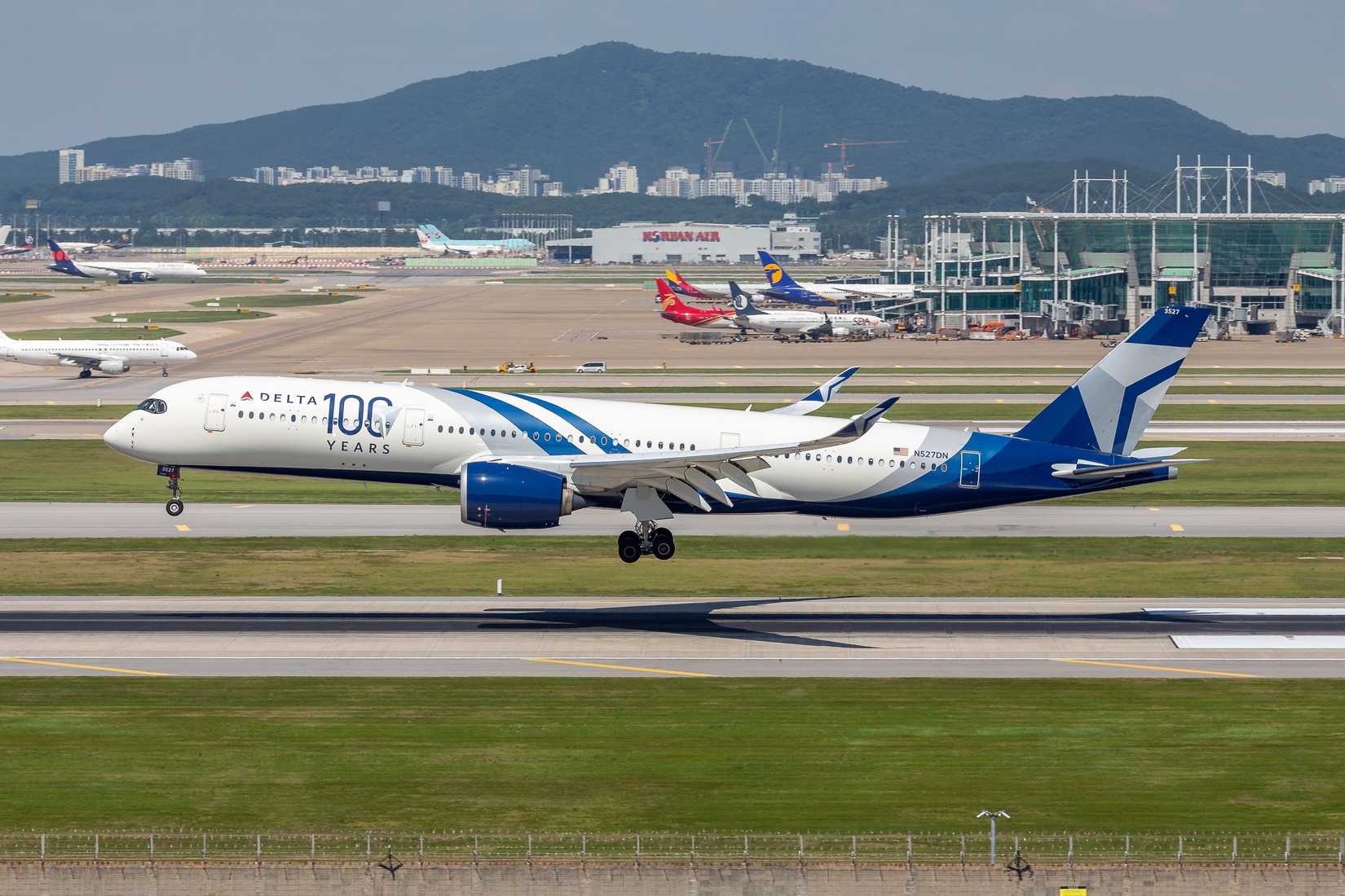 An Airbus A350-941 of Delta Air Lines, featuring a special 100 Years livery, touches down at Incheon Airport in South Korea.
