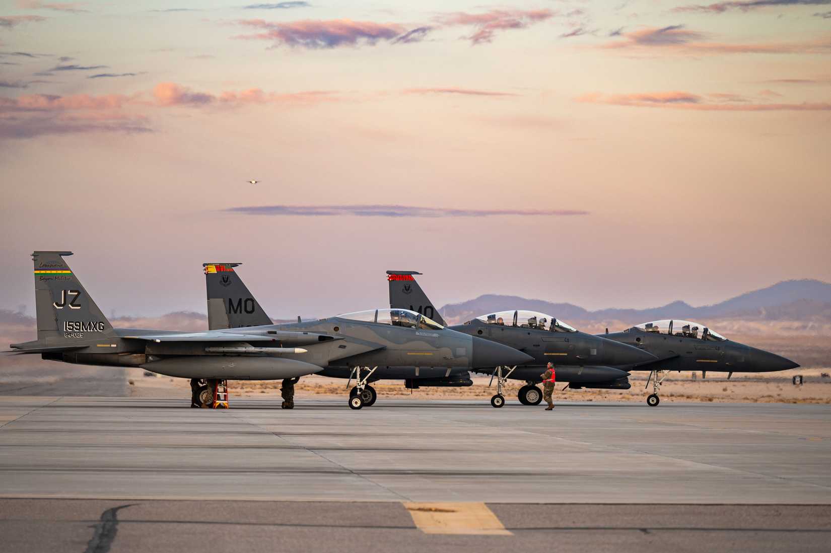 An F-15C Eagle parks next to two F-15E Strike Eagles at Nellis AFB.