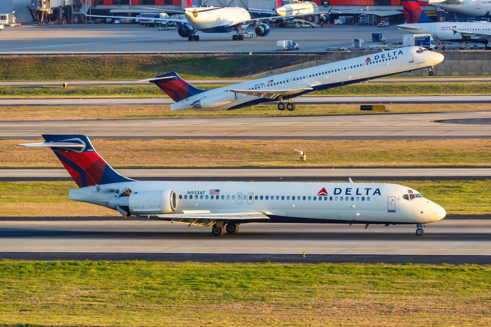 2 Delta Boeing 717s, one taxiing, one taking off