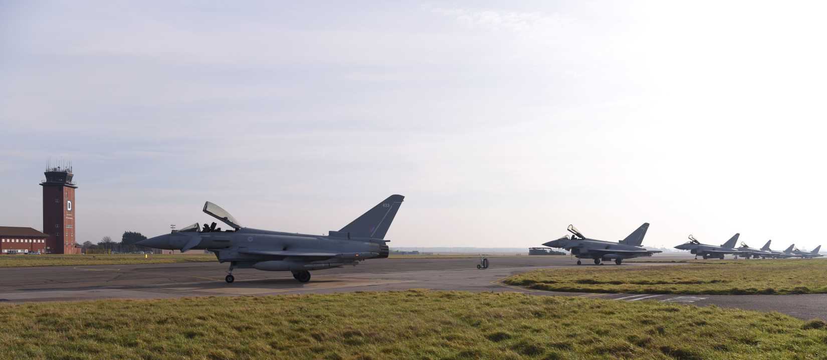 Royal Air Force Eurofighter Typhoons from RAF Coningsby sit on the taxiway.