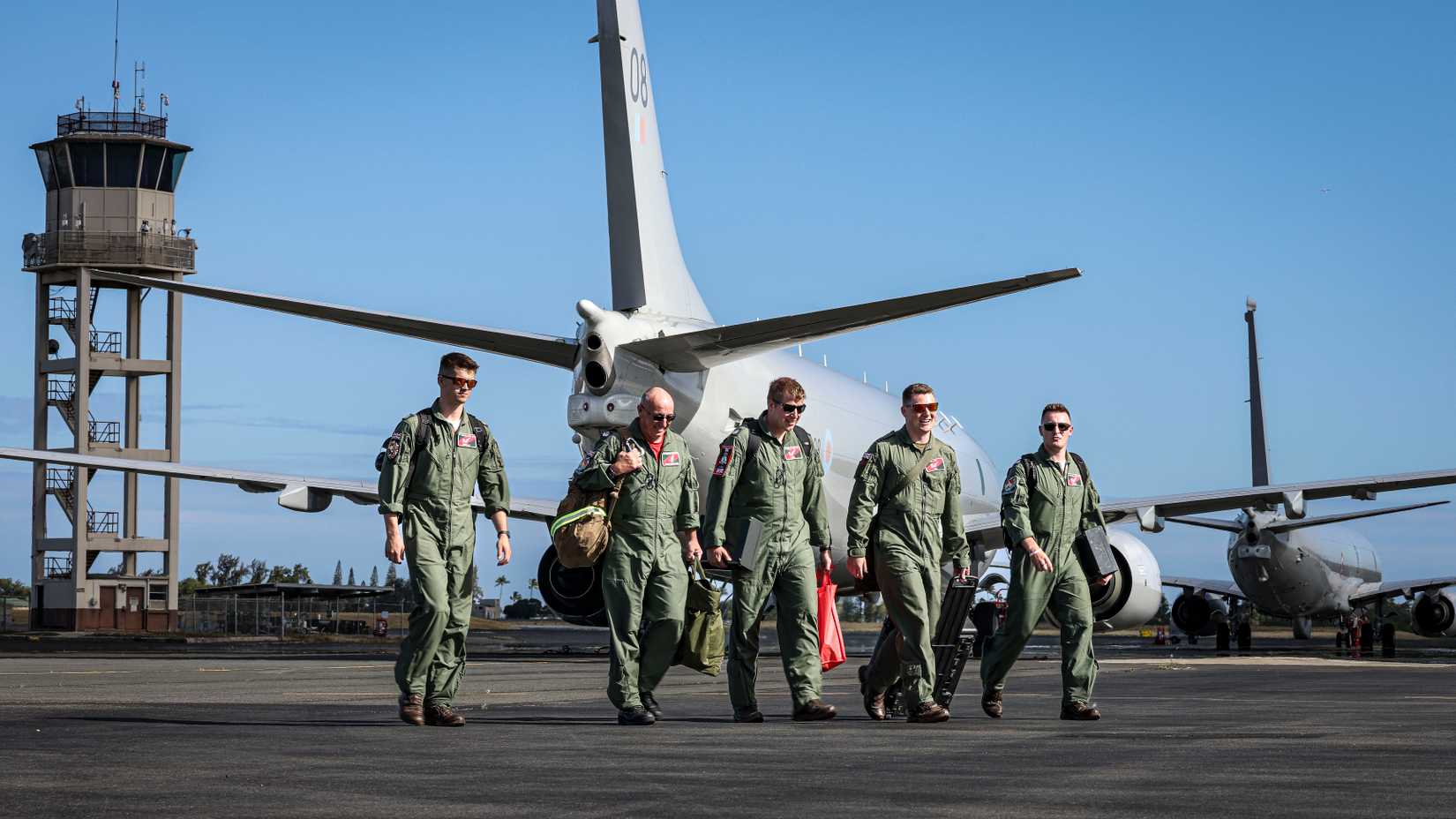 Royal Air Force P-8A Poseidon crew from 201 Squadron walks to their aircraft.