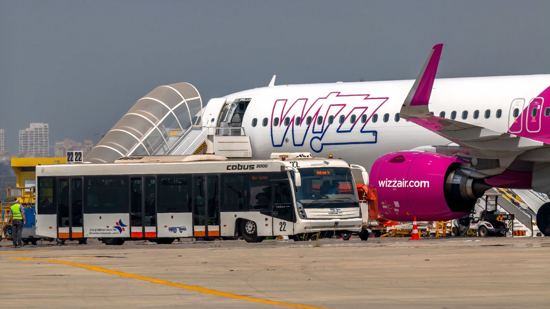 A shuttle bus to transport passengers to a plane is parked next to Wizz Air Airbus A321Neo at Ben Gurion Airport