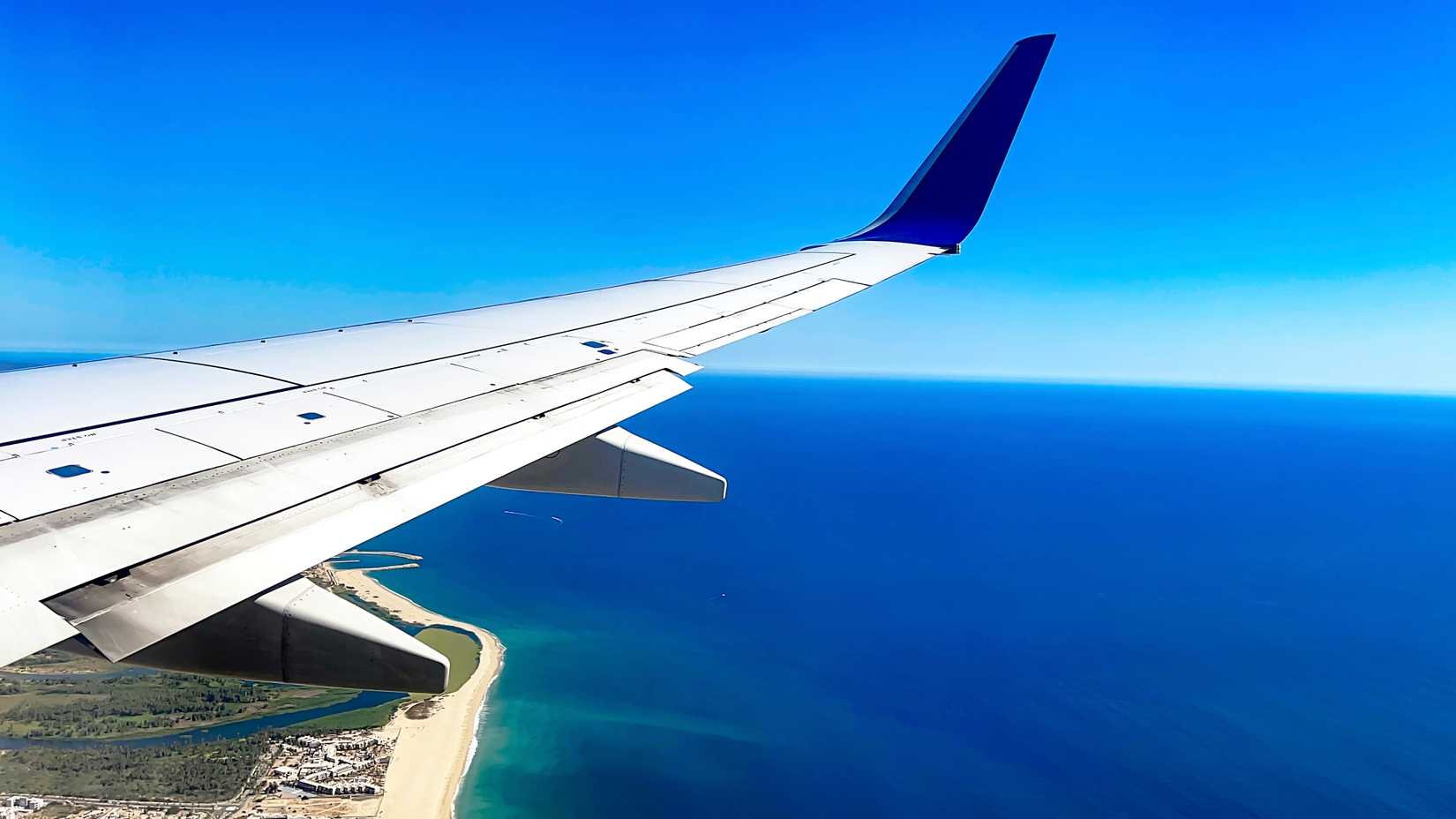 Commercial aircraft flying over the sea of cuts and preparing for landing at Cabo San Lucas International Airport in the state of Baja California Sur, Mexico. Concept aerial view, airplane.