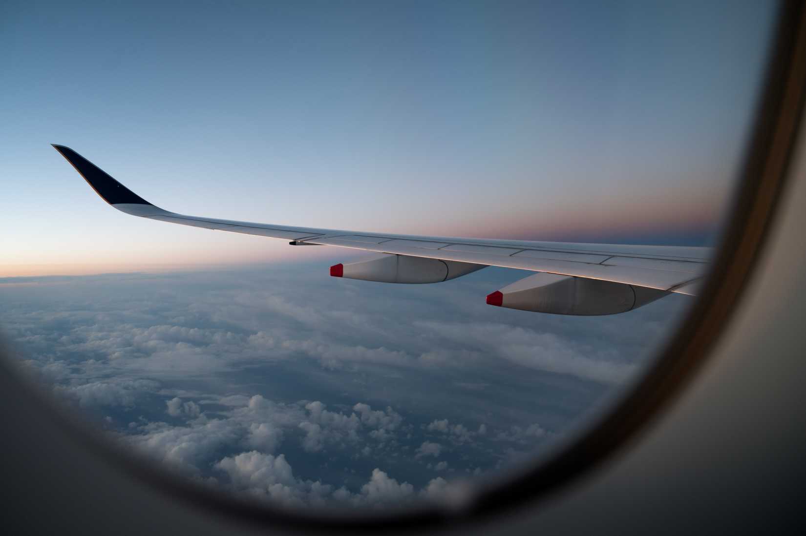 Window seat view of an aircraft wing at cruising altitude, with daybreak in the background Aircraft: A350-900 Ultra Long Range