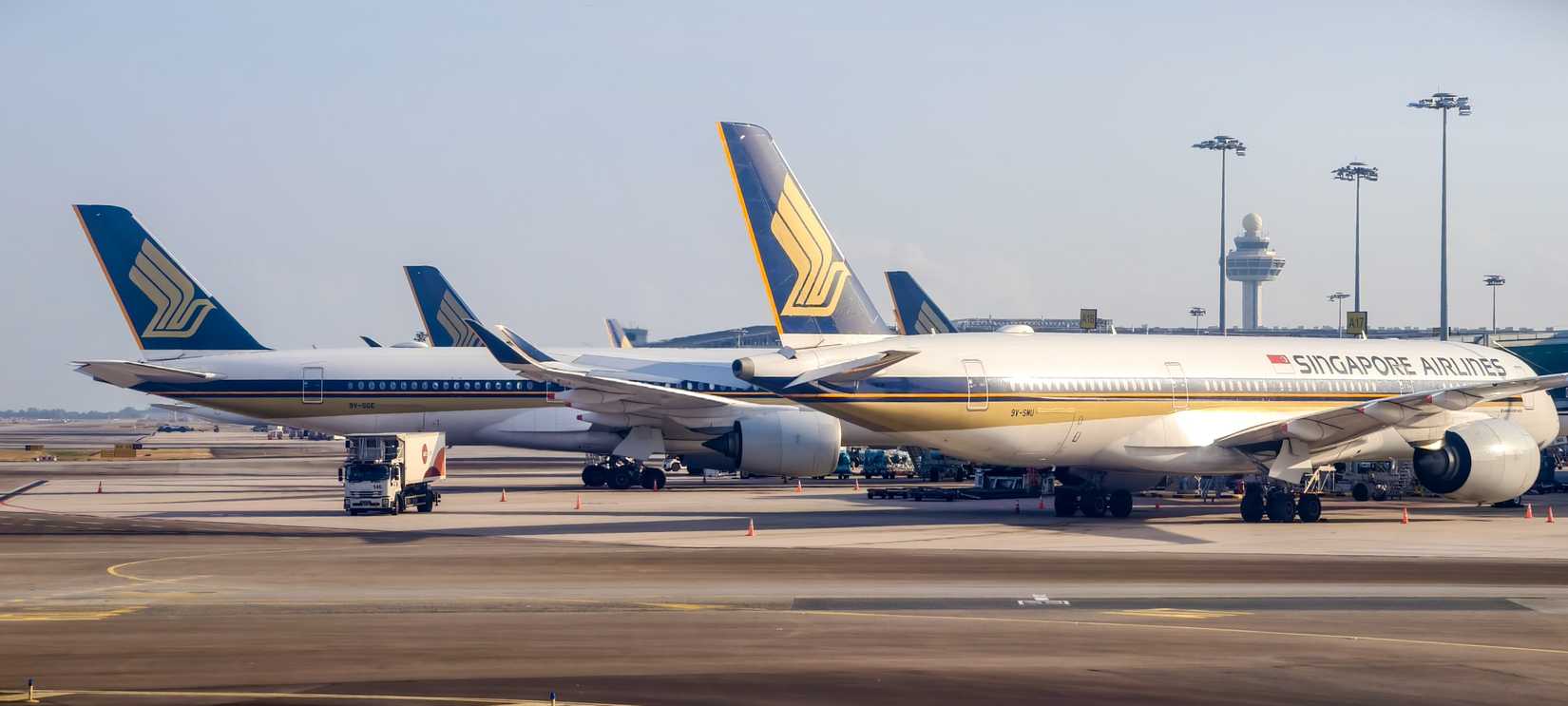 Singapore Airlines aircraft are parked at Changi airport terminal.
