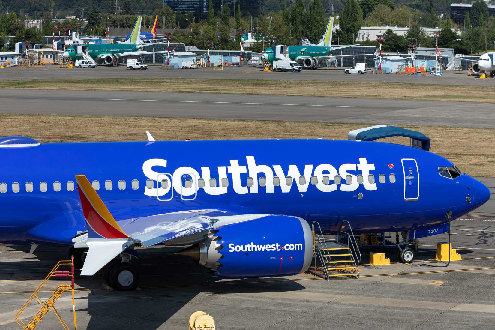 Southwest Boeing 737 MAX airplane, parked at the Renton airliner factory, with furloughed jets in the background.