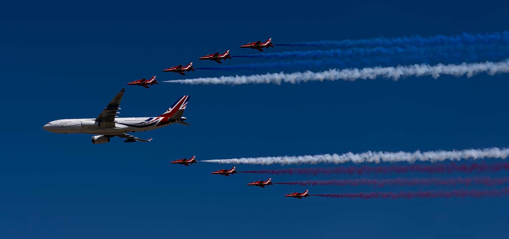 The British Air Force’s Red Arrows and a Government of the United Kingdom Airbus KC2 Voyager conduct a flypast.