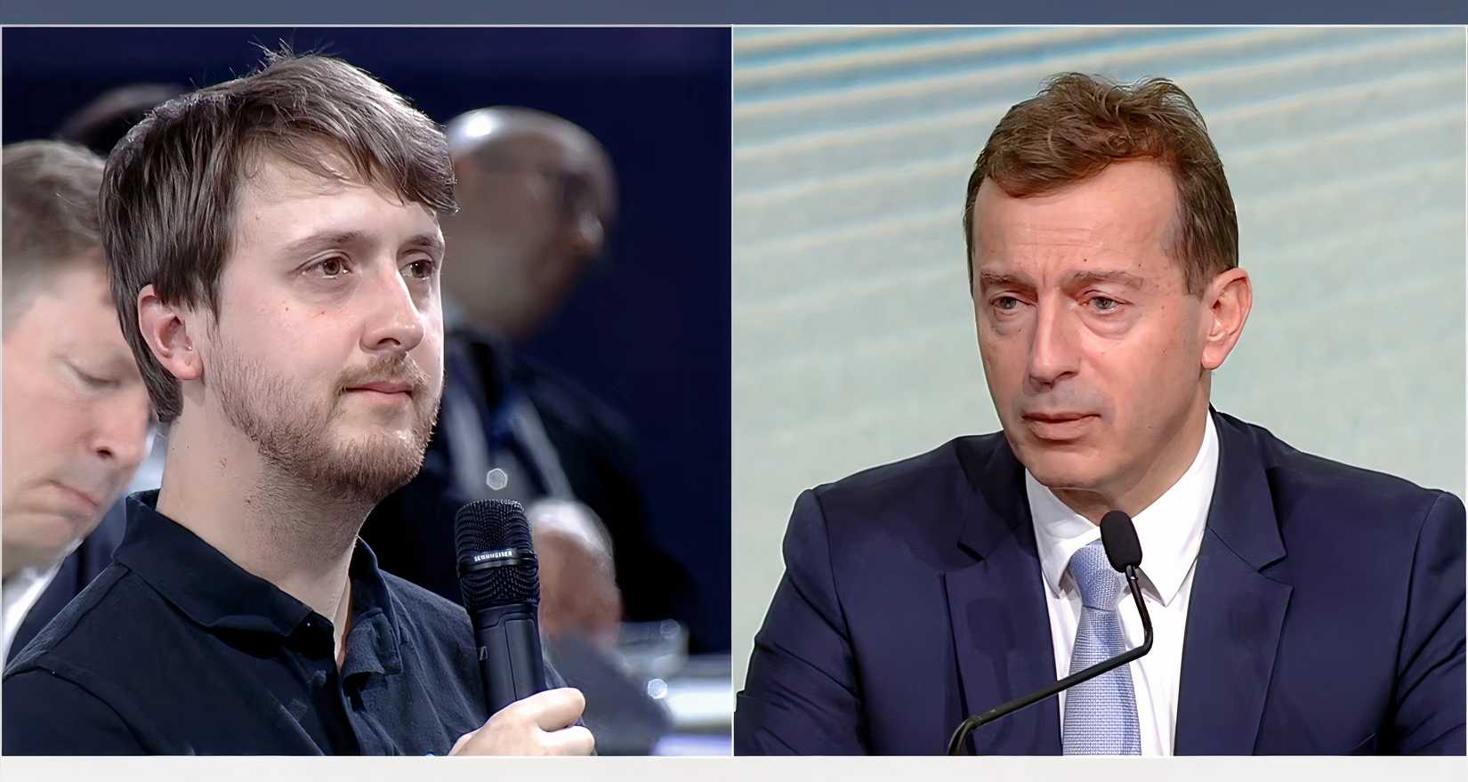 A split-screen image showing two men during what appears to be a formal press conference or presentation.  Left side: A man with brown hair and a light beard is shown in a medium close-up, holding a black microphone to his chin while looking toward the right side of the frame.  Right side: A man in a dark suit, white shirt, and light blue tie is speaking into a podium microphone.  Background: The left side shows a blurred audience in a dimly lit room, while the right side has a brigh