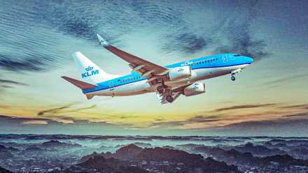 KLM Boeing 737-700 تحلق فوق سماء ملبدة بالغيوم عند غروب الشمس