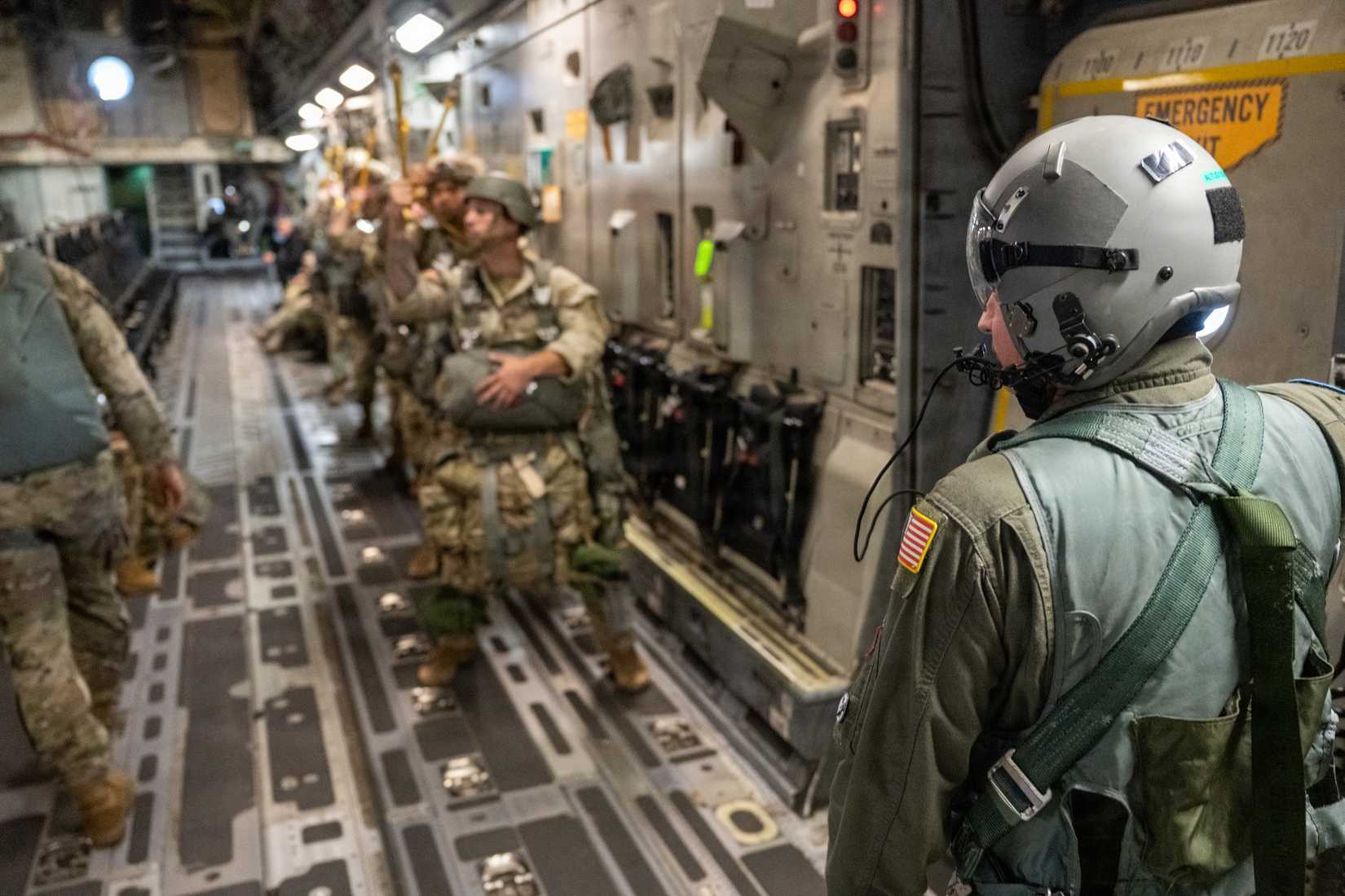 730th Air Mobility Training Squadron instructor loadmaster, stands by the aircraft’s paratroop door with Ranger students.