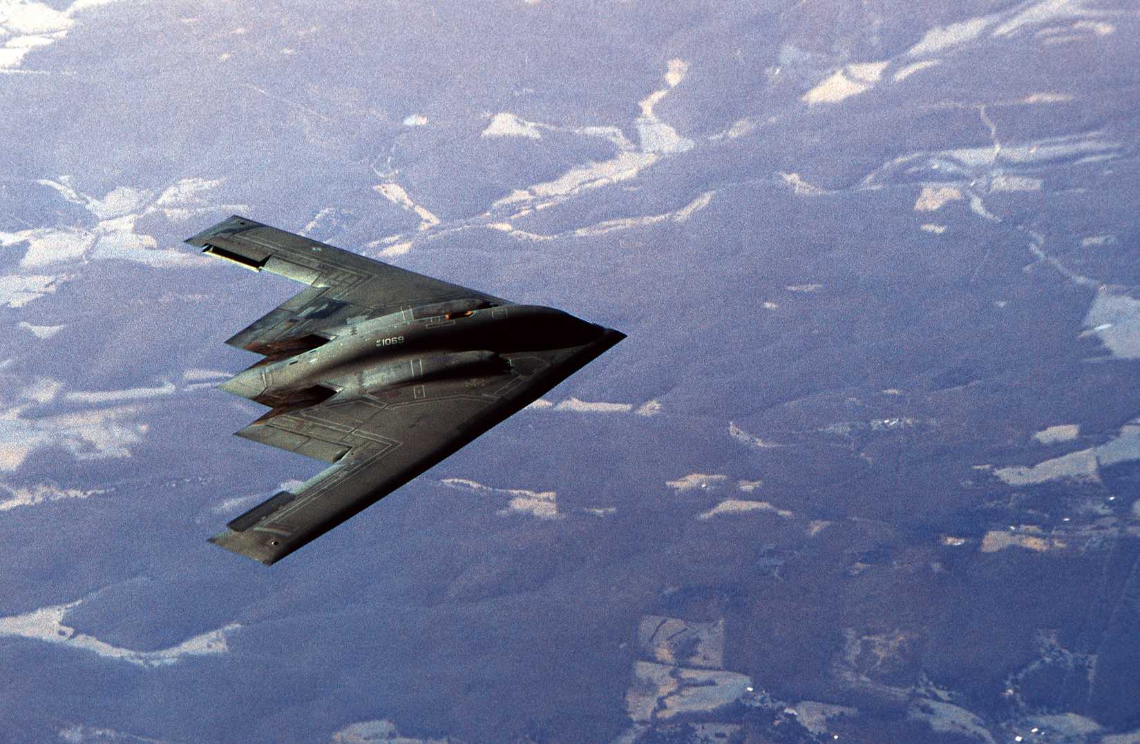 A B-2 Spirit approaches a tanker in flight.